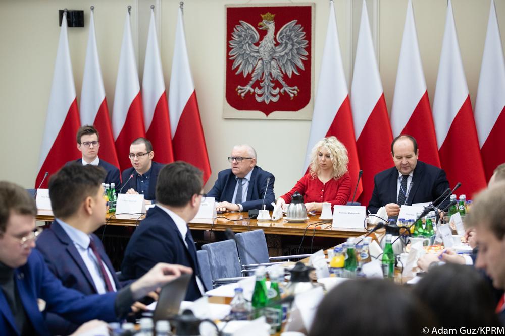 Młodzi siedzą przy stole podczas spotkania.