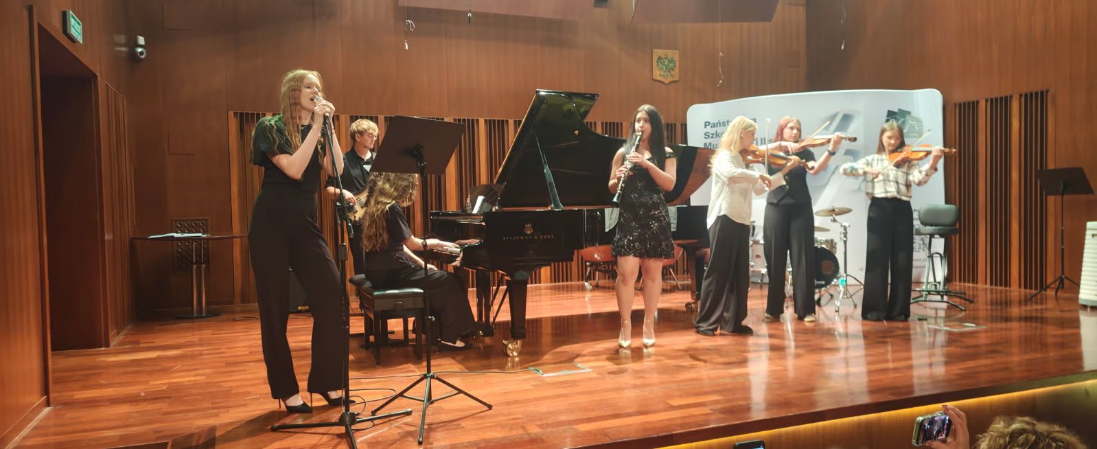 Koncert absolwentów II st. 2026 - Zespół kameralny złożony z 7 uczniów na scenie sali koncertowej szkoły