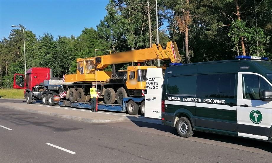 Radiowóz i inspektor ITD obok kontrolowanego zestawu nienormatywnego.