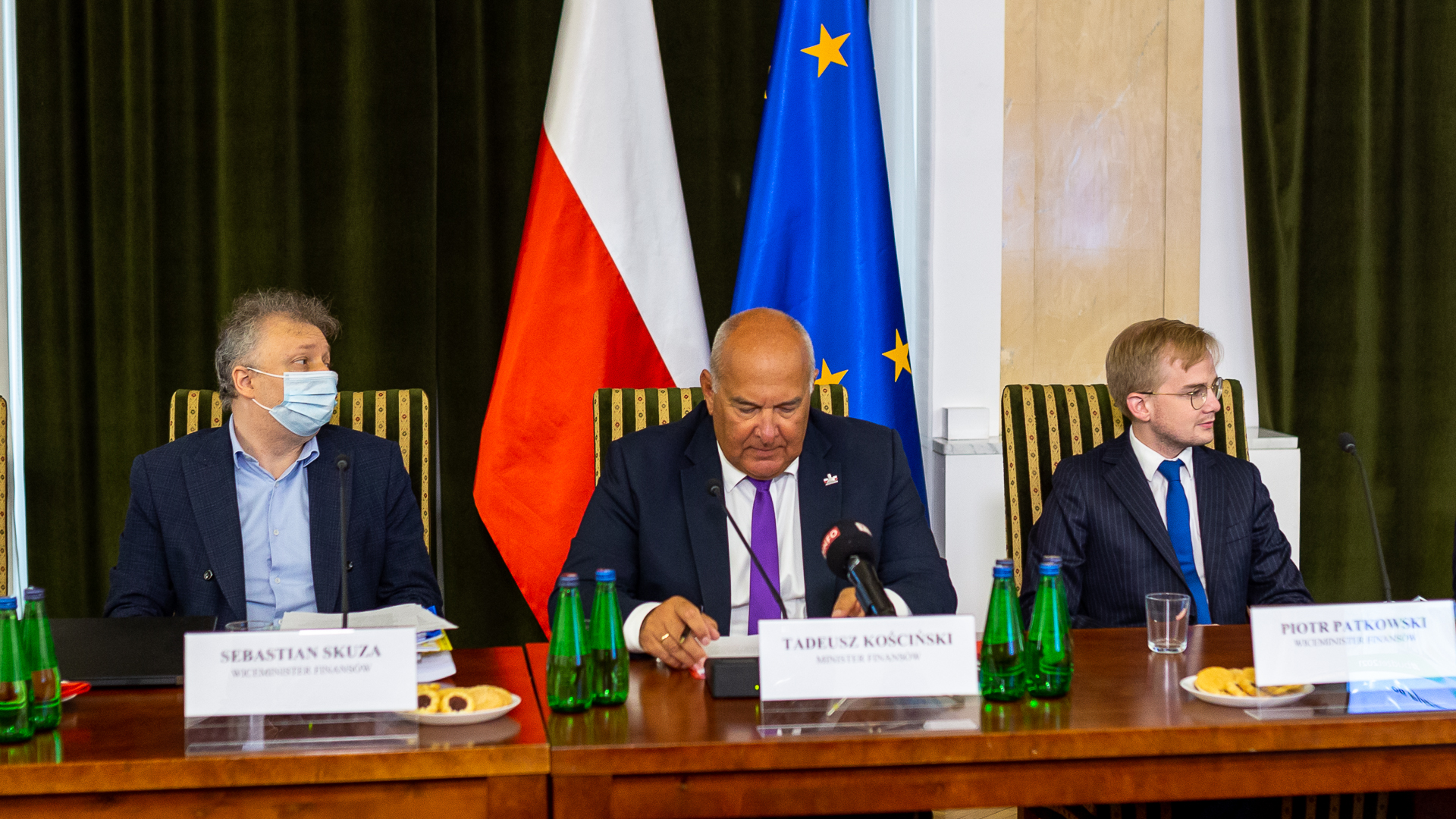 Stół prezydialny, przy którym siedzą od lewej: wiceminister Sebastian Skuza, minister finansów Tadeusz Kościński, wiceminister Piotr Patkowski