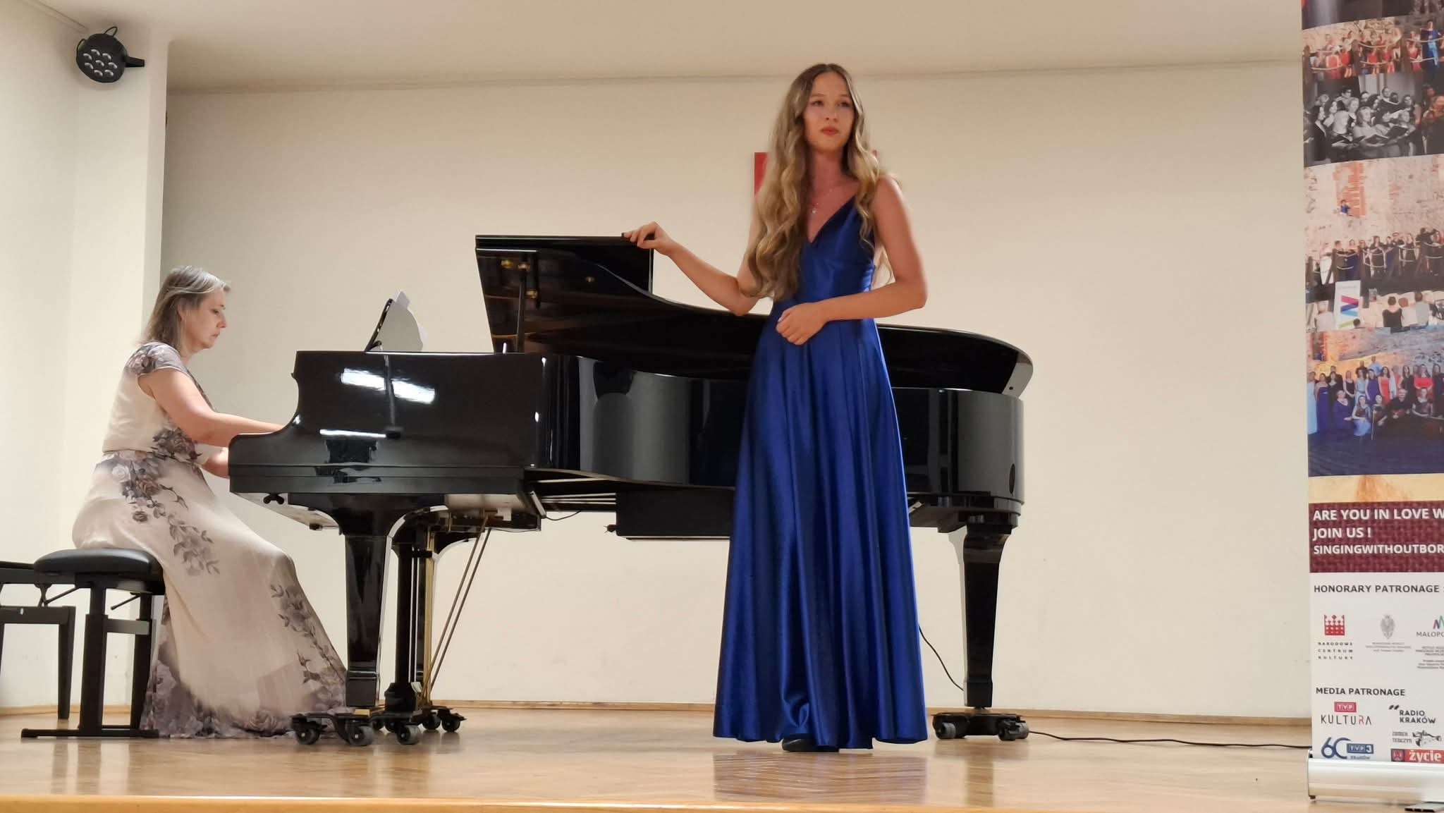 Amelia Szmidt na scenie w trakcie konkursu, w niebieskiej sukience