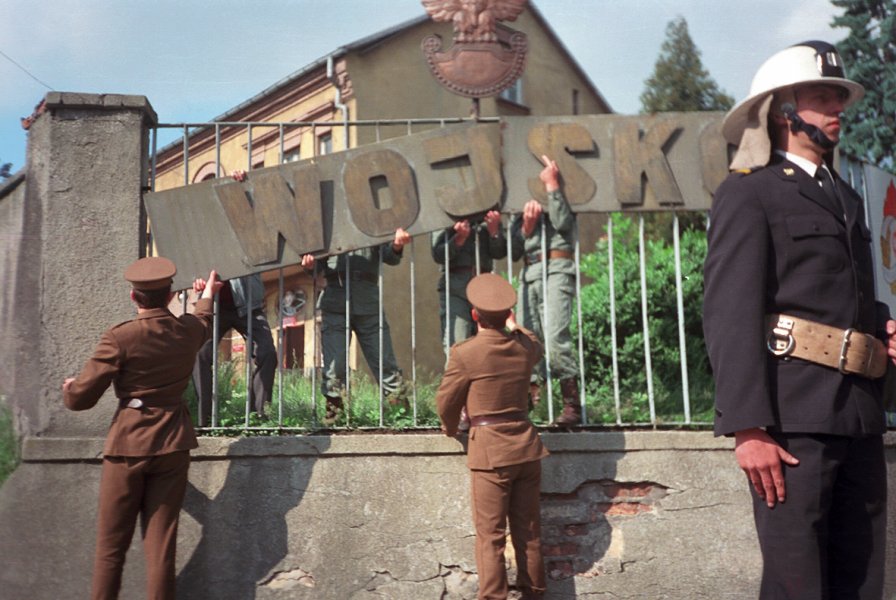Demontowanie napisu na ogrodzeniu jednostki przez Wojsko Polskie w obecności strażaków