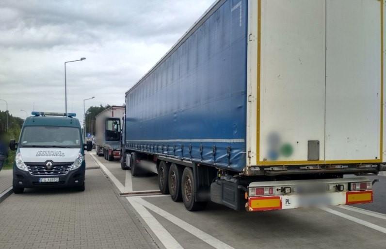 Ciężarówka i stojący obok niej radiowóz ITD.