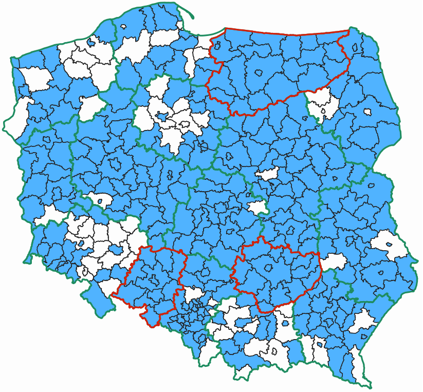Ilustracja przedstawia mapę Polski z podziałem na powiaty, na której zaznaczone kolorem niebieskim są powiaty umożliwiajace pobieranie pobieranie danych dotyczących geometrii działek i budynków. A dodatkowo czerwonym konturem zaznaczone są województwa, w których wszystkie powiaty mają własne usługi WFS.