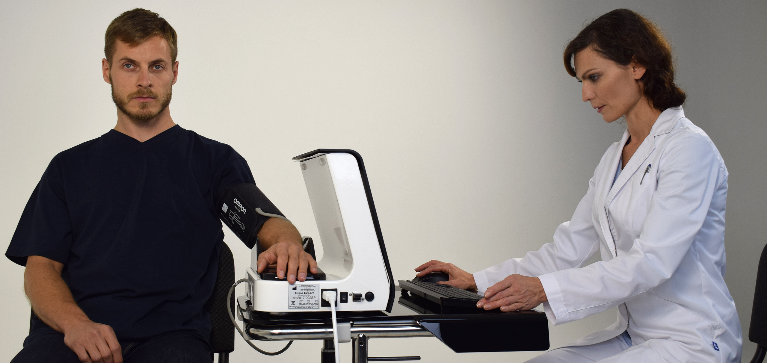 Mężczyzna badany urządzeniem przez lekarkę