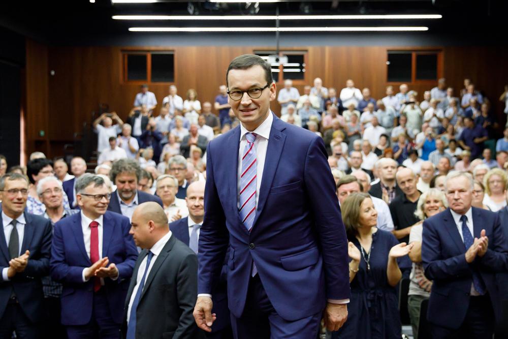 Premier Mateusz Morawiecki, a w tle uczestnicy spotkania.