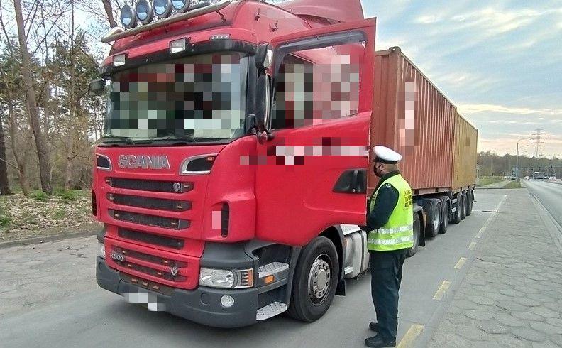 Inspektor kujawsko-pomorskiej ITD pobiera dokumenty od kierowcy znacznie przeładowanej ciężarówki.