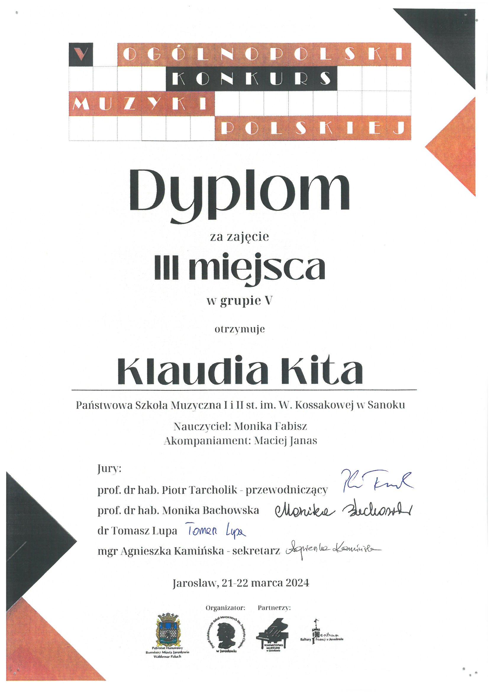 Dyplom - Klaudia Kita- 3 miejsce w V Ogólnopolskim Konkursie Muzyki Polskiej w Jarosławiu. Czarne litery na białym tle, w rogach kolorowe trójkąty.