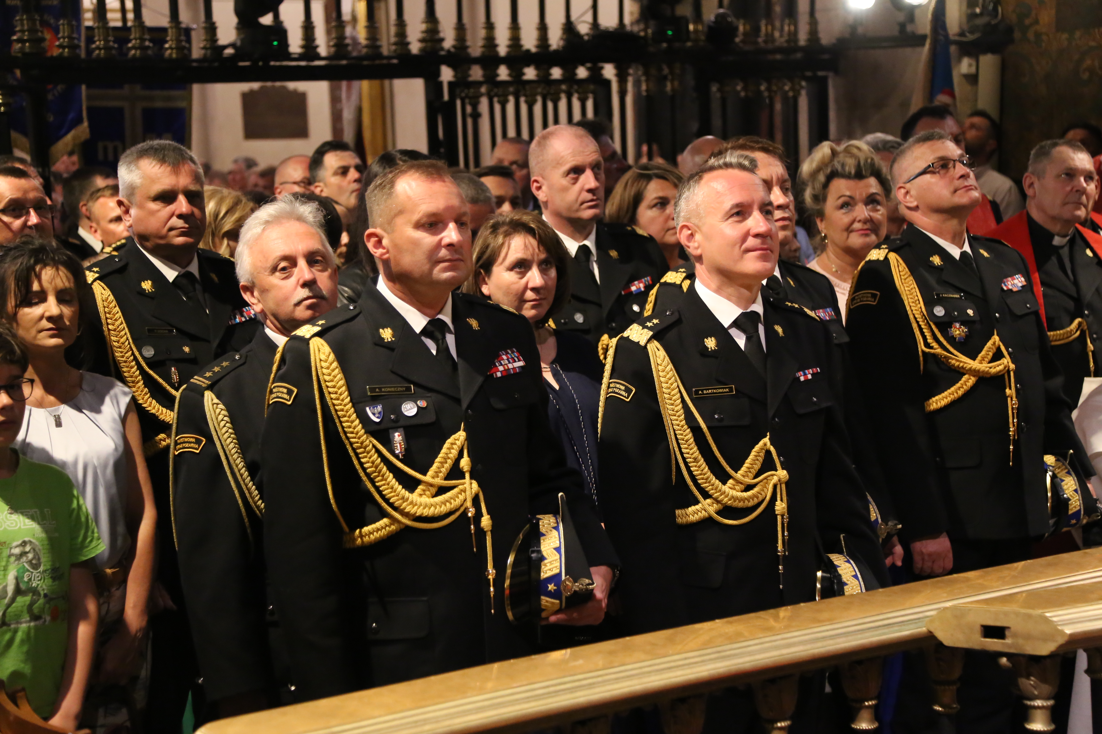 W ławach kościelnych podczas Apelu Jasnogórskiego stoją strażacy wraz z rodzinami