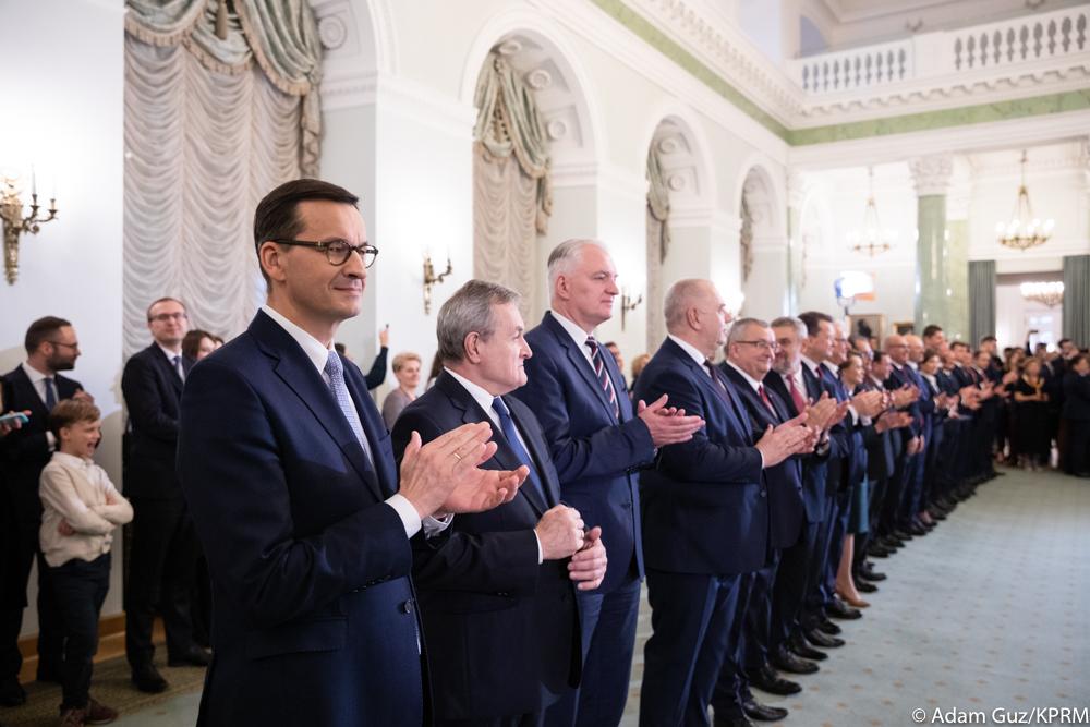 Premier oraz ministrowie stoją podczas uroczystości.