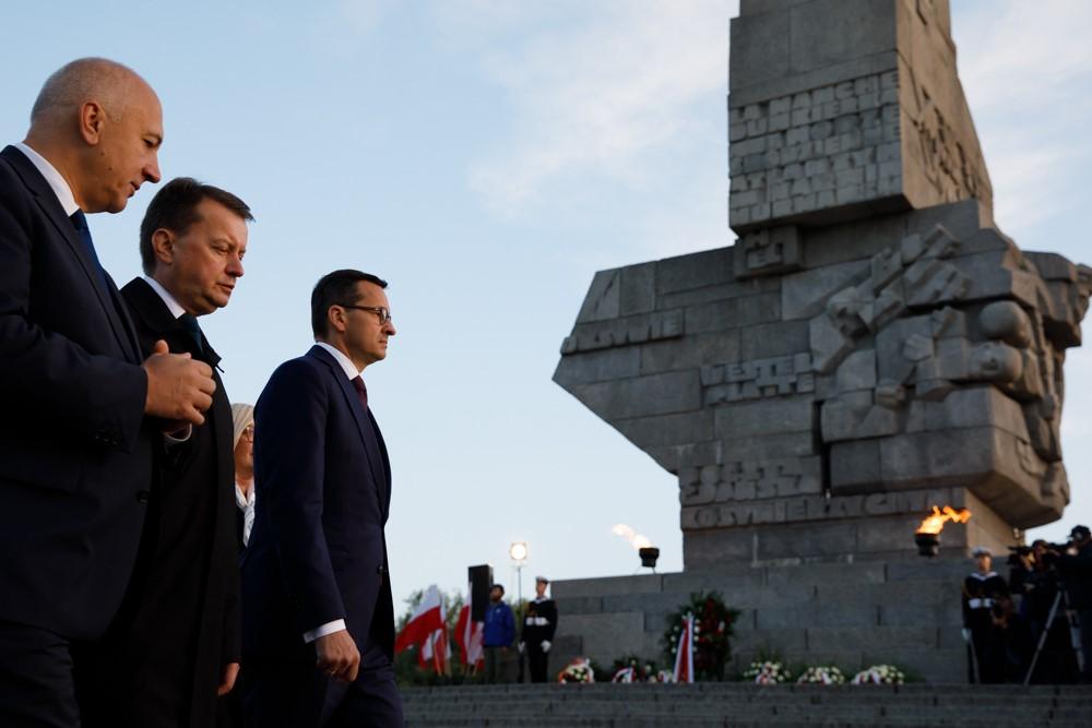 Premier Mateusz Morawiecki, minister Mariusz Błaszczak i minister Joachim Brudziński chylą głowy przed pomnikiem na Westerplatte.