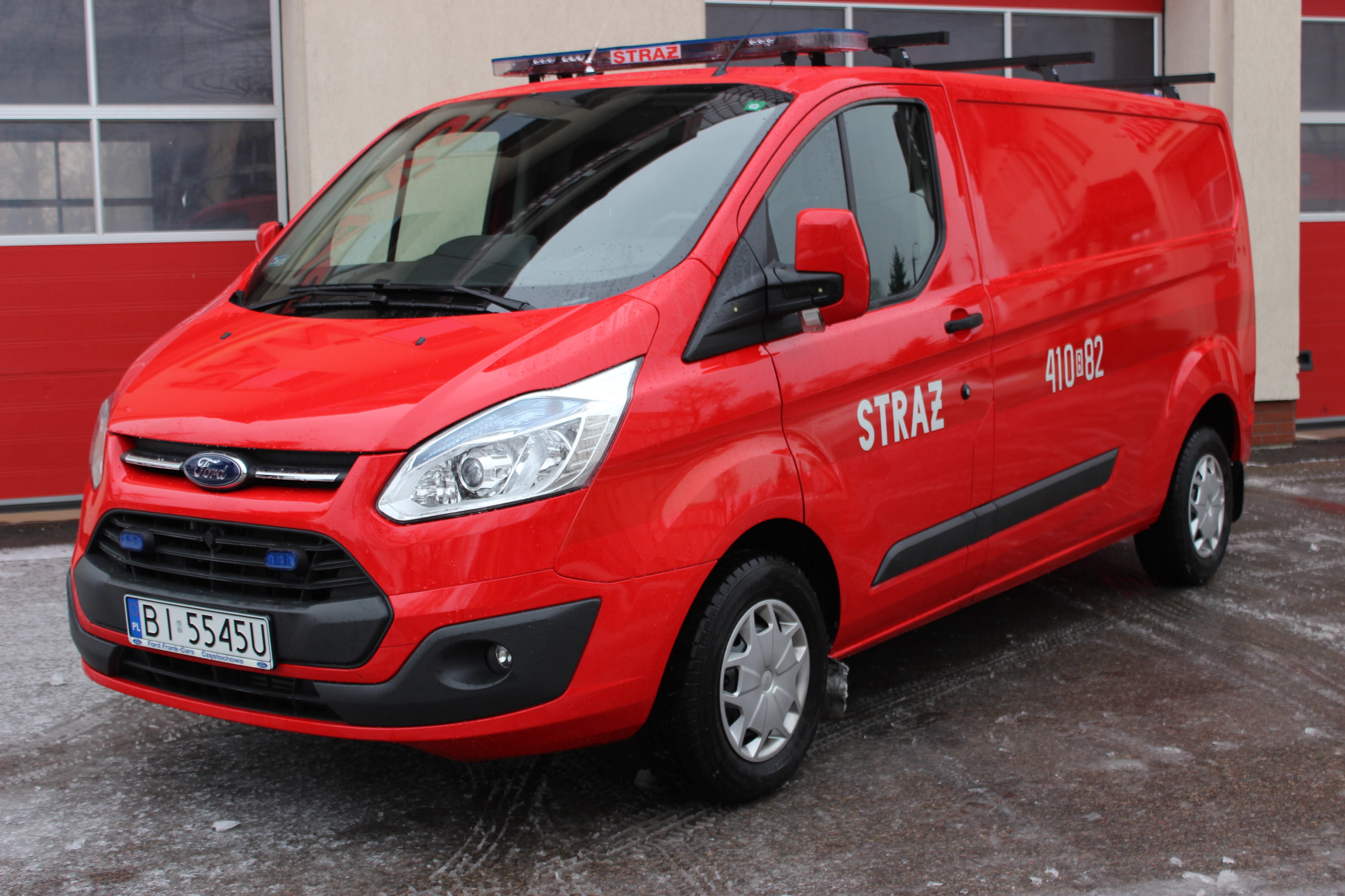 Zdjęcie przedstawia samochód kwatermistrzowski FORD Transit stojący na tle strażnicy.