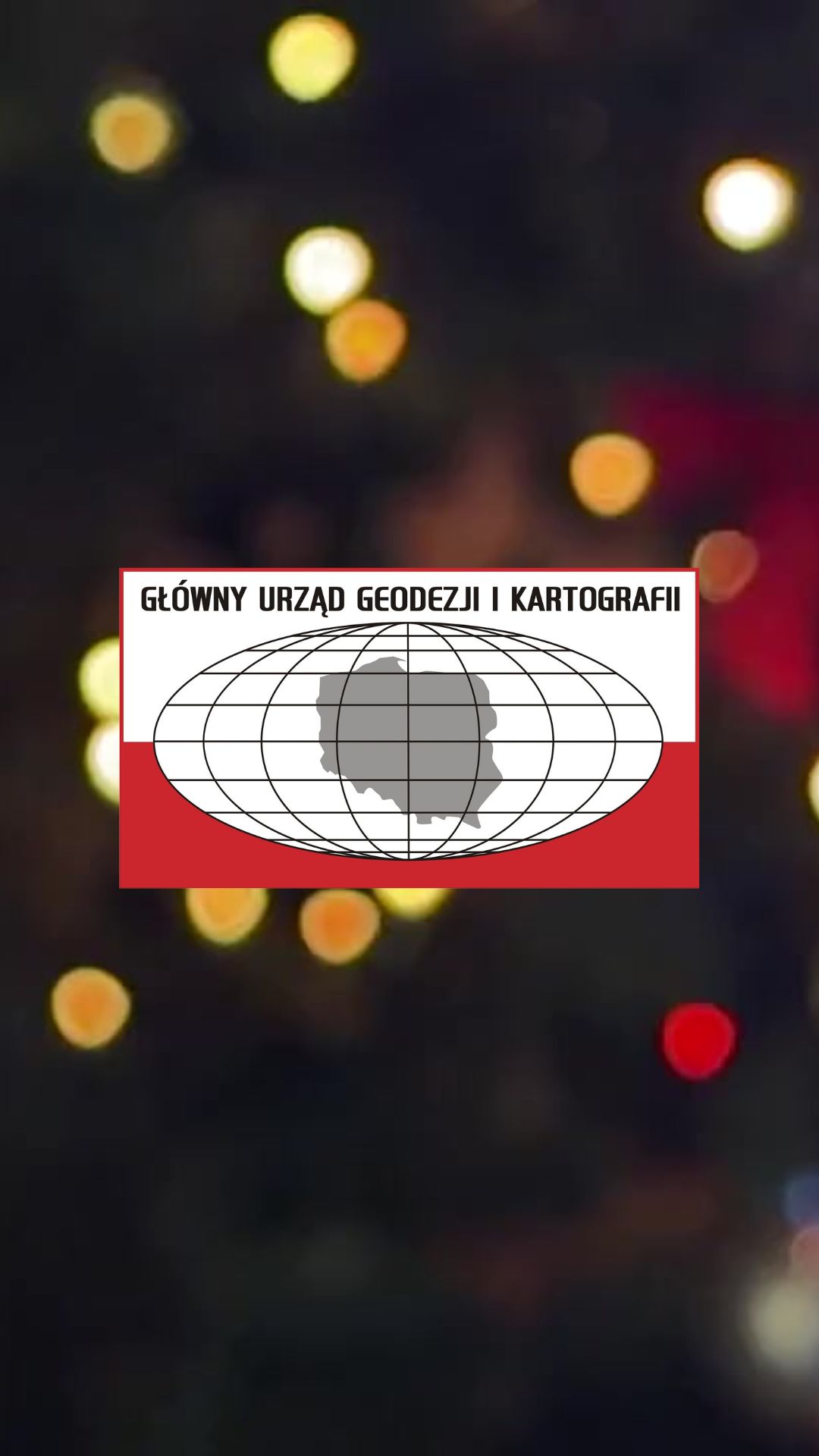 logotyp Głównego Urzędu Geodezji i Kartografii na rozmytym tle