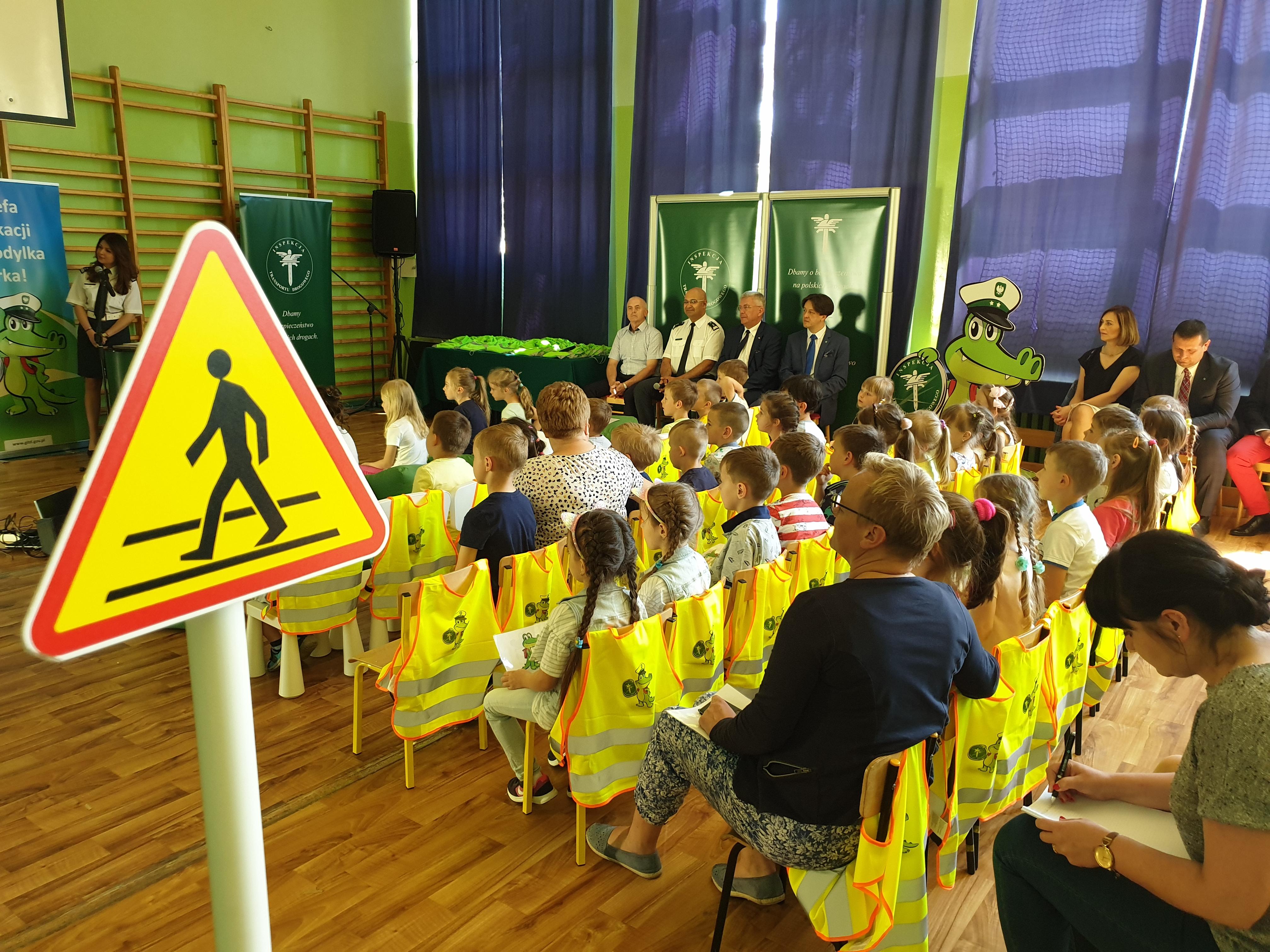 Dzieci siedzące na krzesełkach w tle prowadzący lekcję