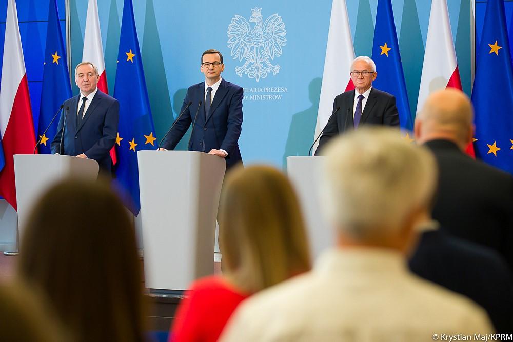 Minister Henryk Kowalczyk, premier Mateusz Morawiecki oraz minister Krzysztof Tchórzewski stoją podczas konferencji.