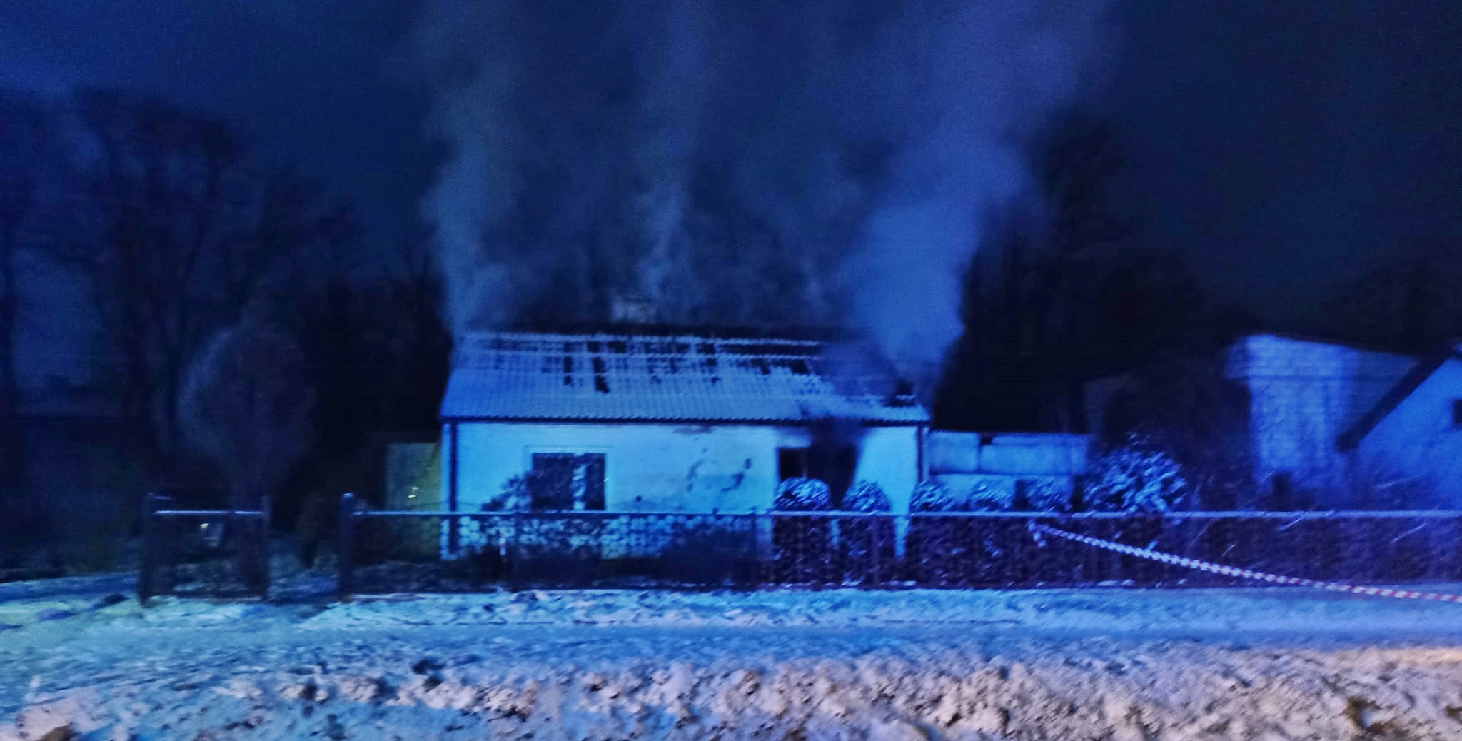 Pożar budynku mieszkalnego. Na zdjęciu budynek, z którego wydobywa się dym.