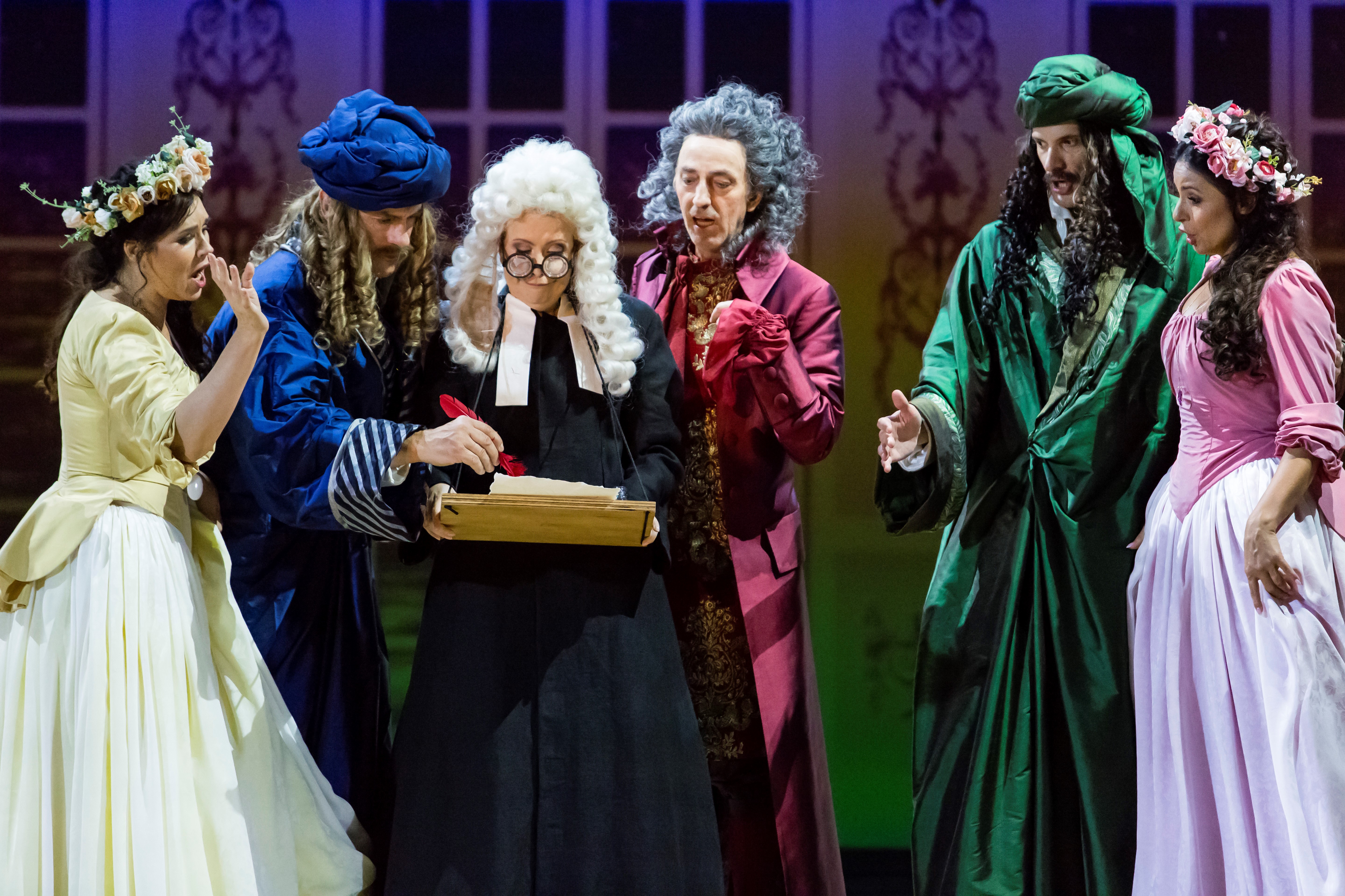 Scena zbiorowa z opery, aktorzy w barwnych strojach podczas występu