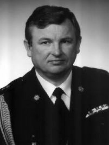 Zdjęcie portretowe czarno białe byłego Komendanta Powiatowego Państwowej Straży Pożarnej w Lublińcu starszego kapitana Mariana Nocunia w mundurze galowym w latach od 1992 do 2008.