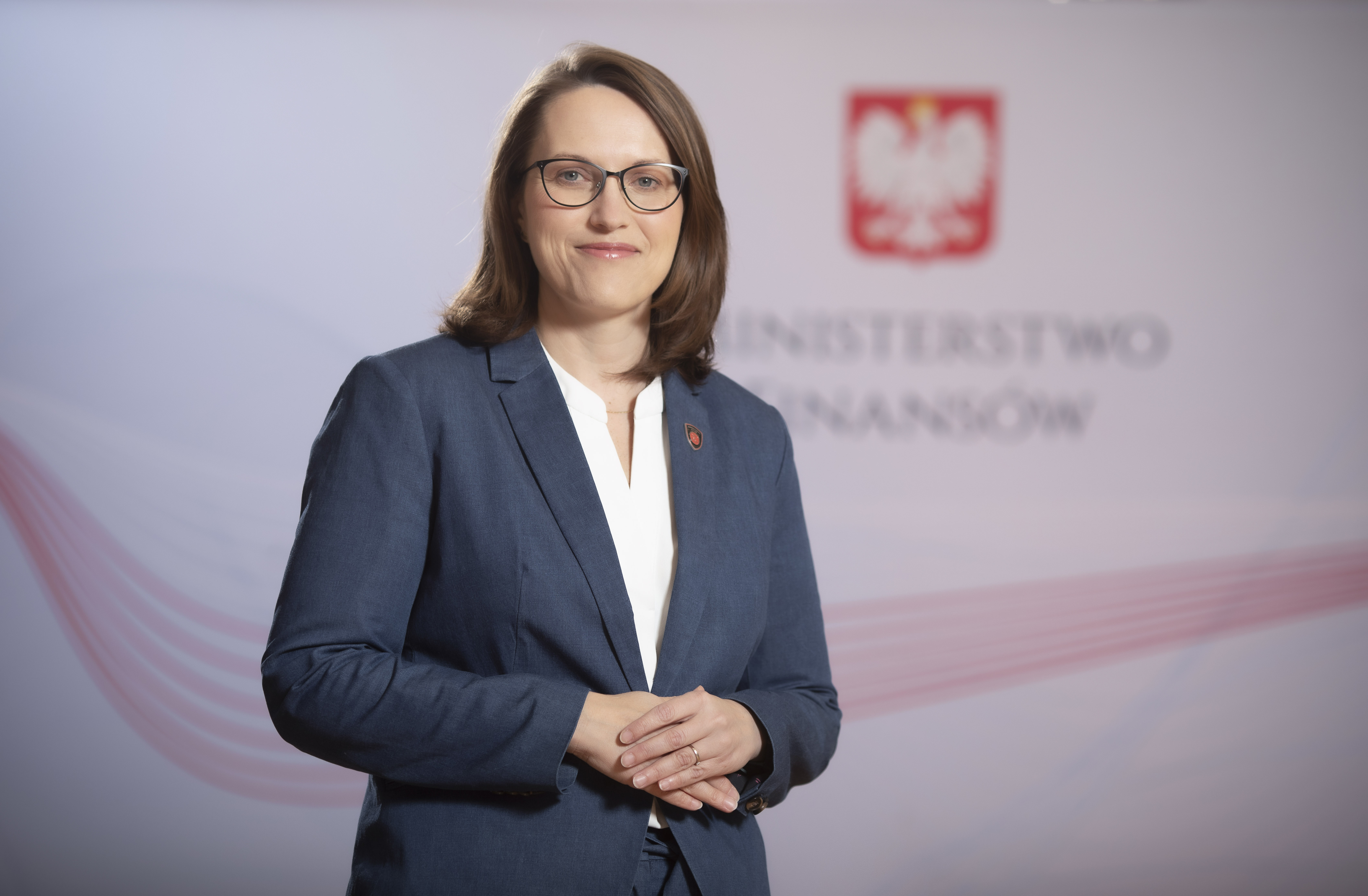 Magdalena Rzeczkowska - w tle godło i napis Ministerstwo Finansów