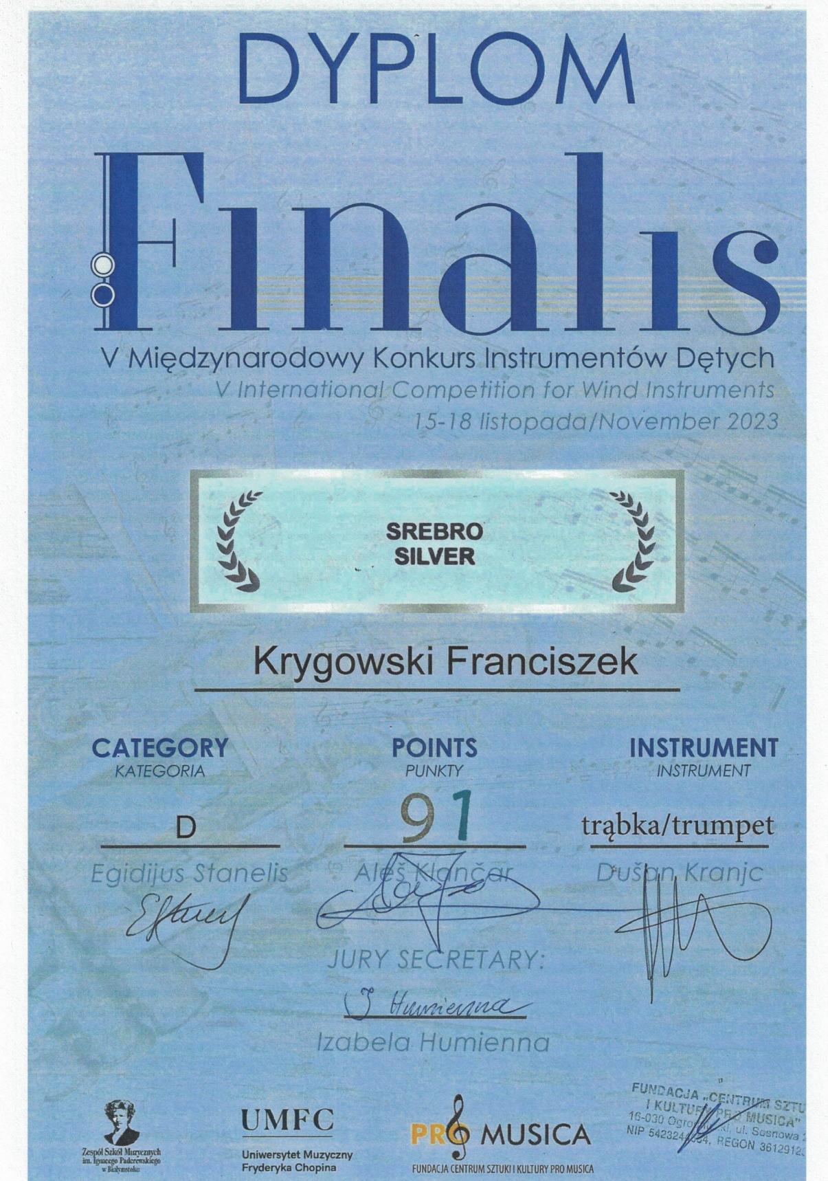 Dyplom na niebieskim tle, na górze napis: DYPLOM, Finalis V Międzynarodowy Konkurs Instrumentów Dętych 15-18 listopada 2023 r., SREBRO, Krygowski Franciszek, Kategoria D, Punkty 91, trąbka, UMFC