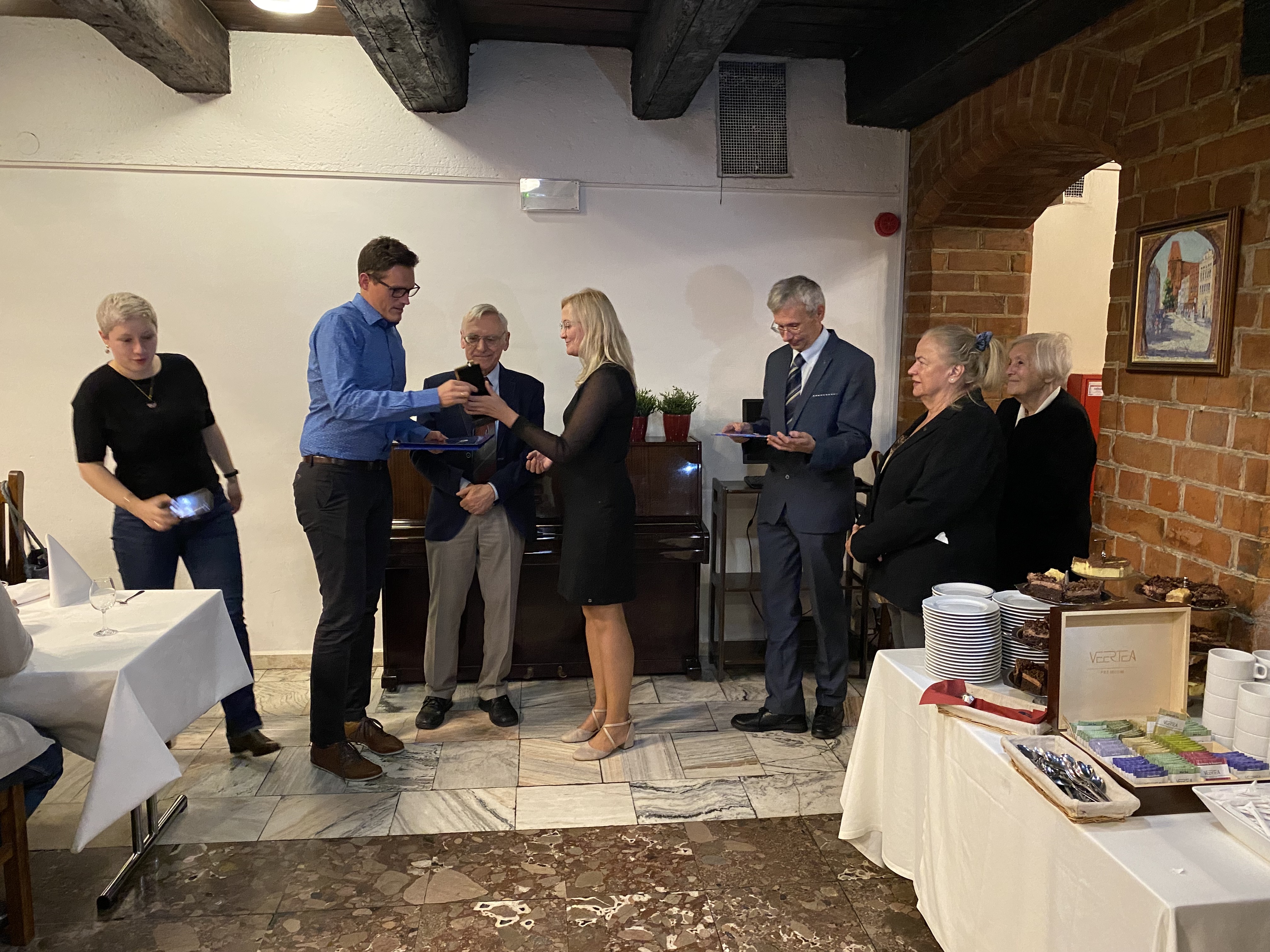 Zdjęcie przedstawia wręczenie pamiatkowych statuetek za Konkursy Mapa Roku 2021 oraz Internetowa Mapa Roku 2021/2022