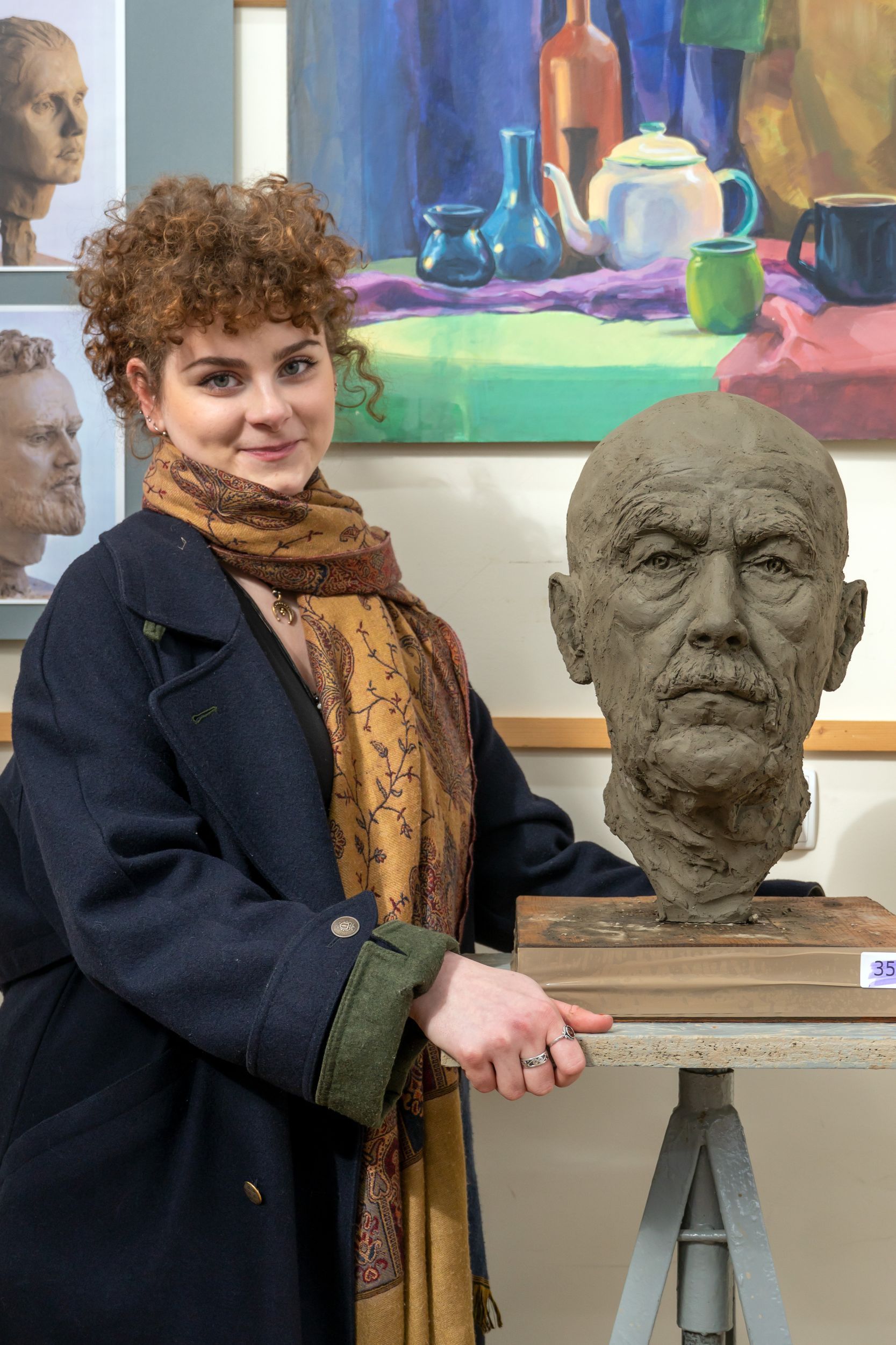 zdjęcie przedstawia uczennicę kieleckiego plastyka Kamilę Tarapata wraz z wykonaną przez nią rzeźbą w glinie głowy modela
