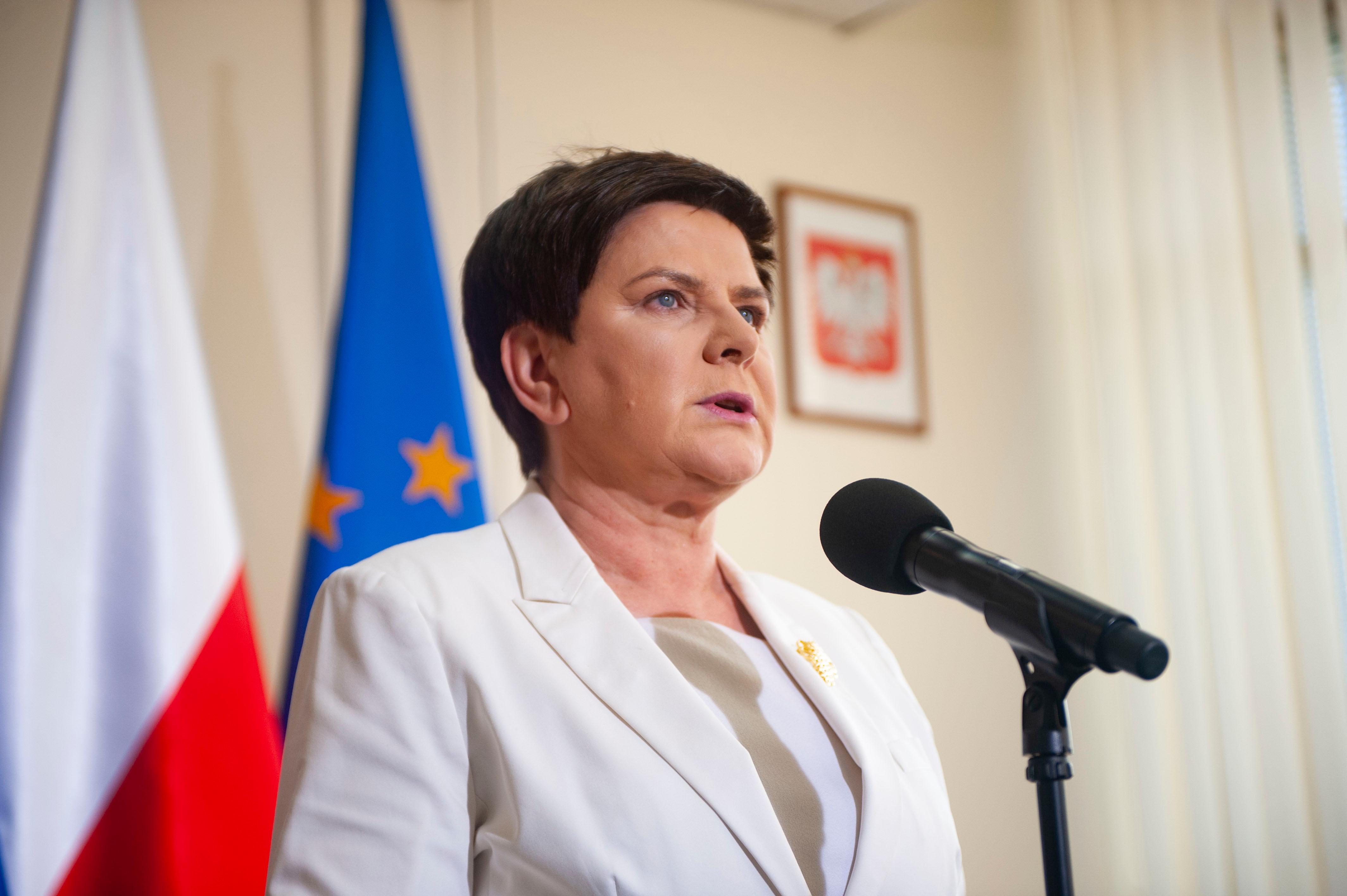 Premier Beata Szydło stoi przy mikrofonie.