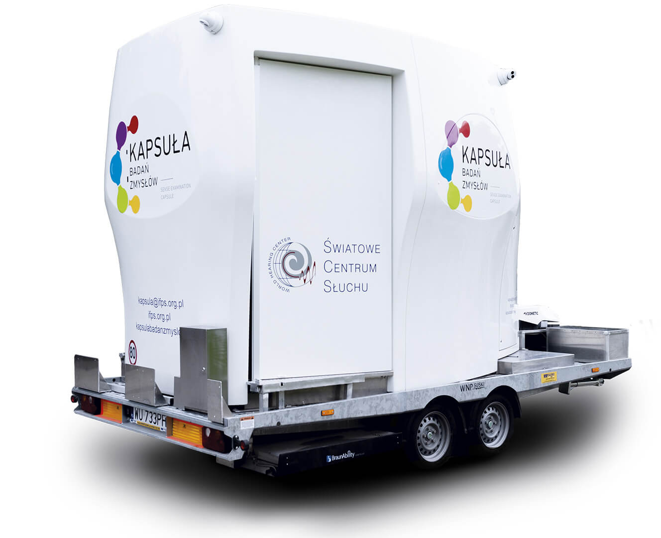 Mobilna Kapsuła Badań Zmysłów, biała, umieszczona na podwoziu, trochę przypomina wóz kempingowy