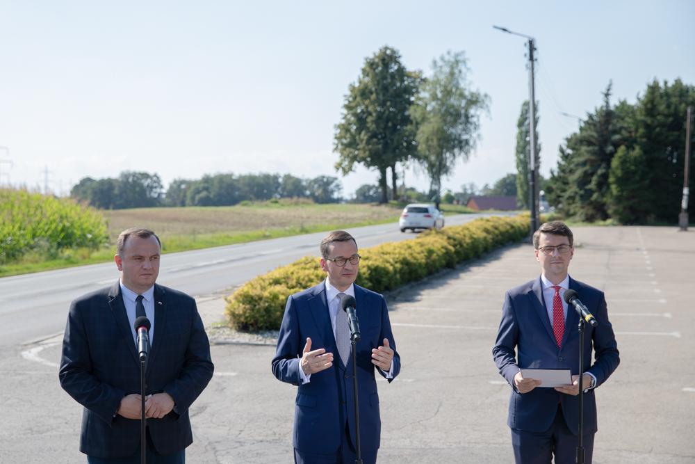 Premier przy mikrofonie podczas briefingu.