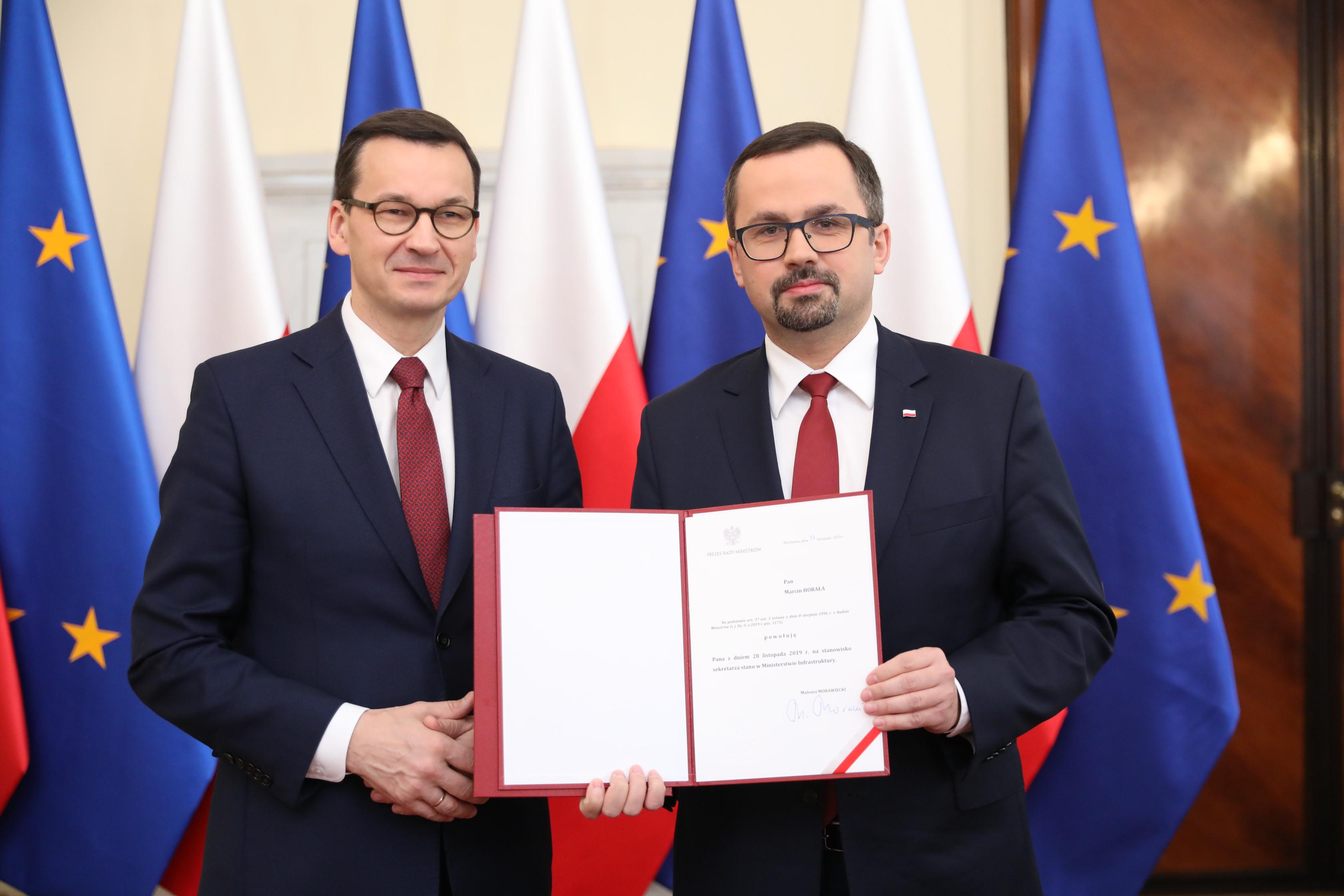 Premier Mateusz Morawiecki i minister Marcin Horała trzymają akt powołania.