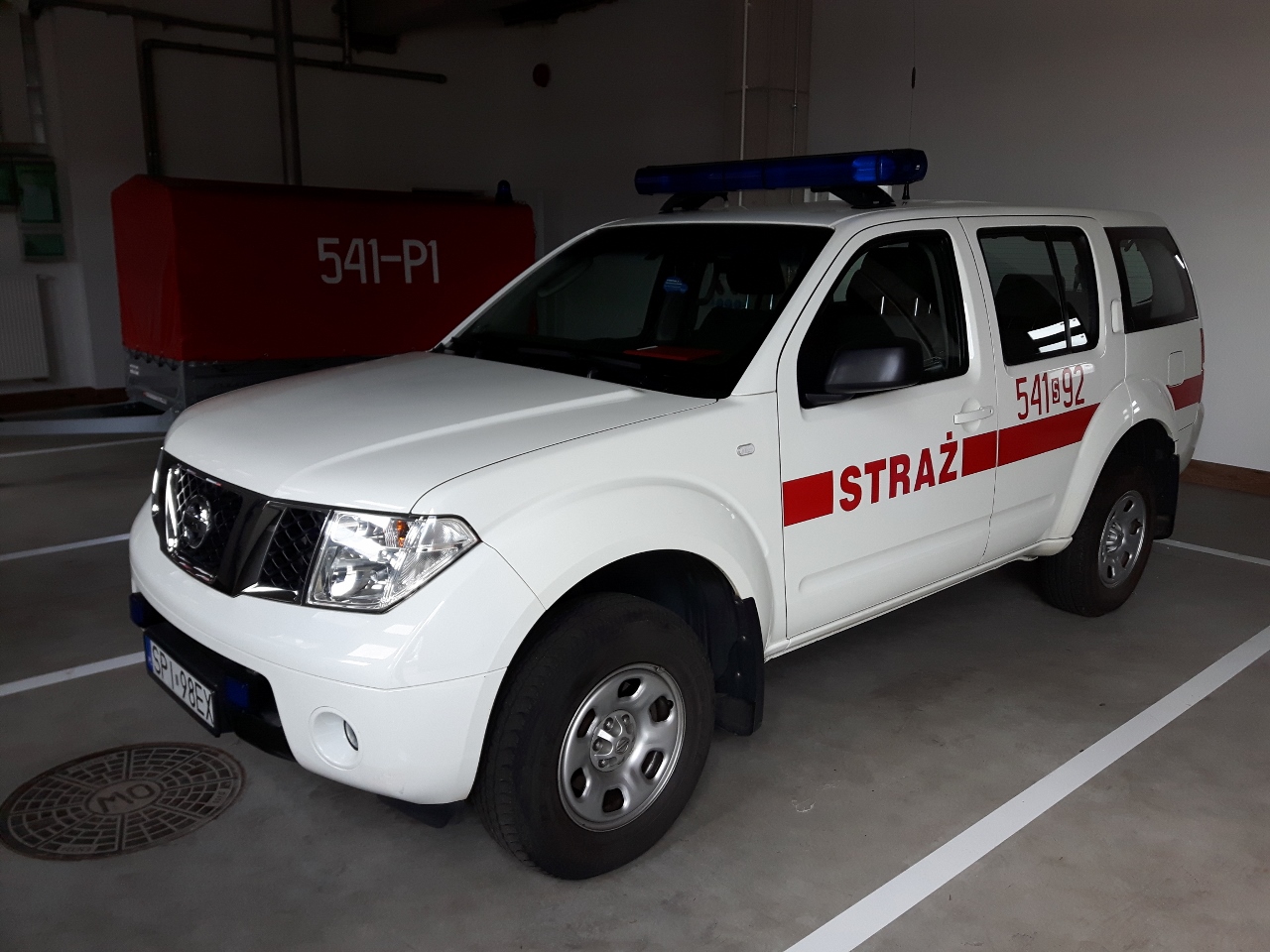 Zdjęcie przedstawia lekki samochód rozpoznawczo-ratowniczy marki Nissan Pathfinder w kolorze białym