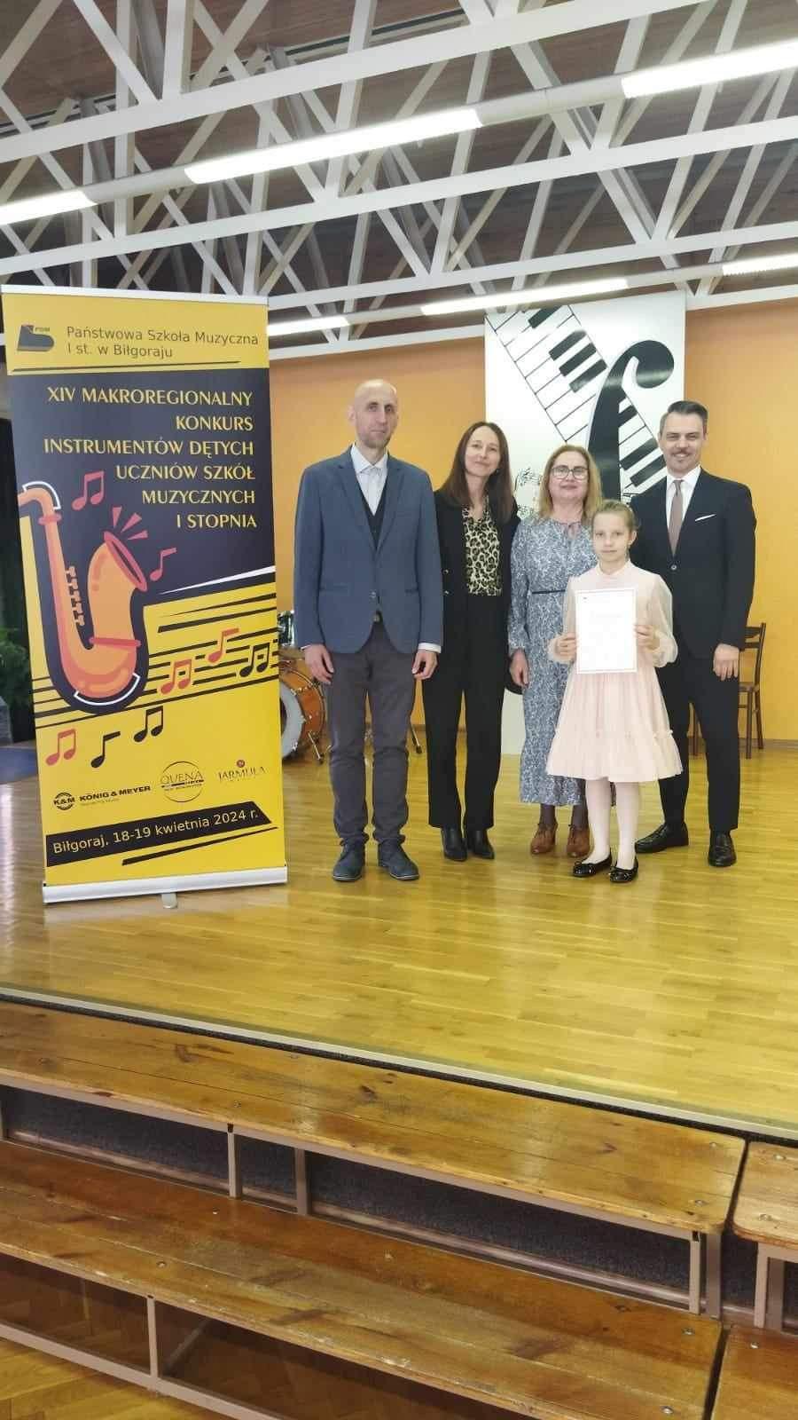 Zdjęcie uczestników oraz Jury pozujących na scenie szkoły