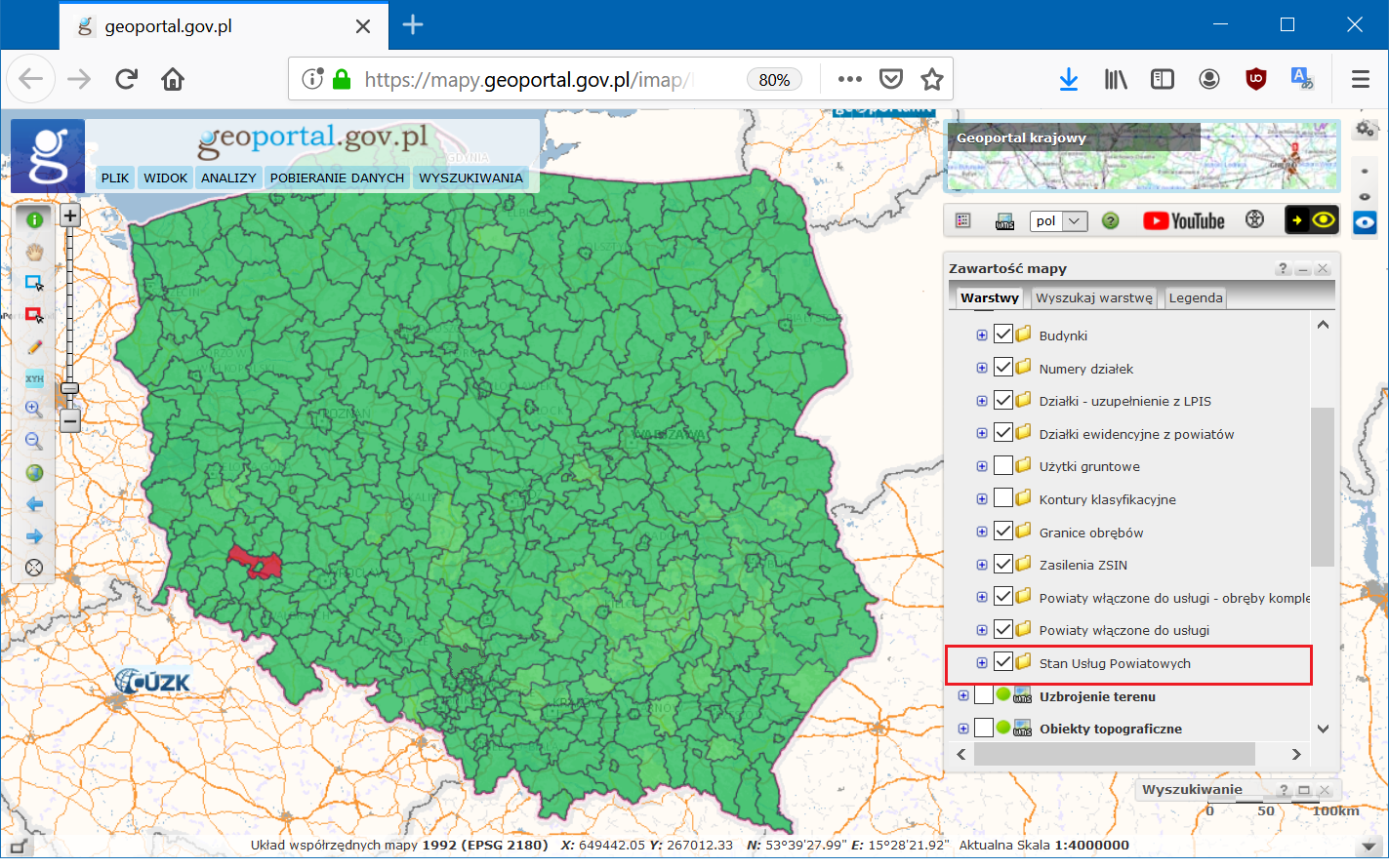 Ilustracja przedstawia zrzut ekranu ze strony geoportal.gov.pl, na którym znajduje się mapa Polski z podziałem na powiaty. Powiat legnicki oznaczony jest kolorem czerwonym, pozostałe zaś na zielono.