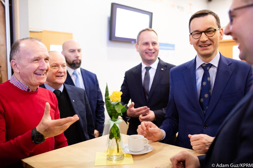 Premier Mateusz Morawiecki przy stoliku razem z przedsiębiorcami.