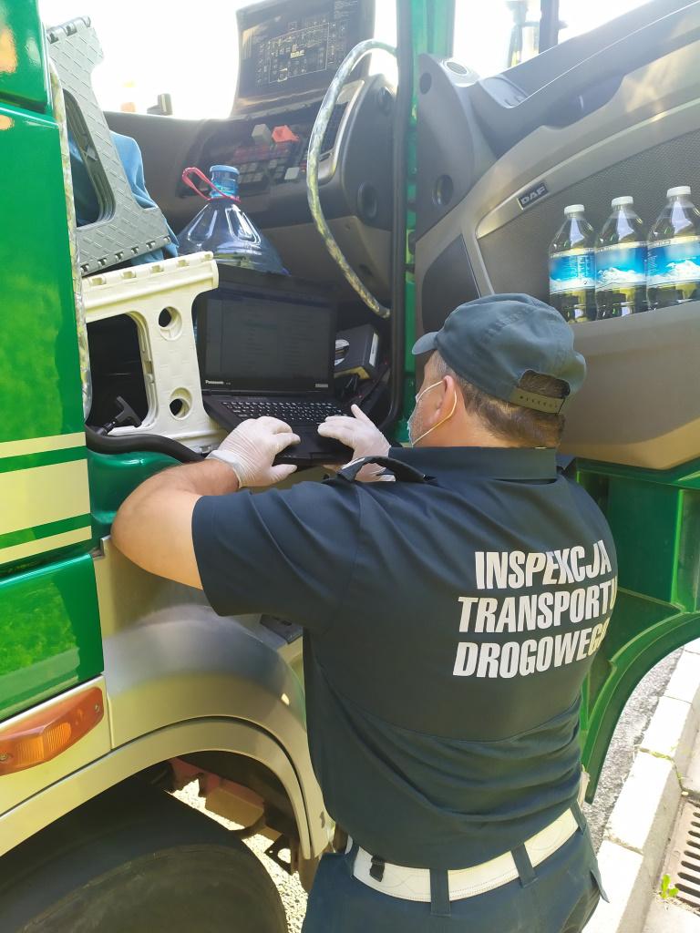 Inspektor przy kabinie ciężarówki z laptopem