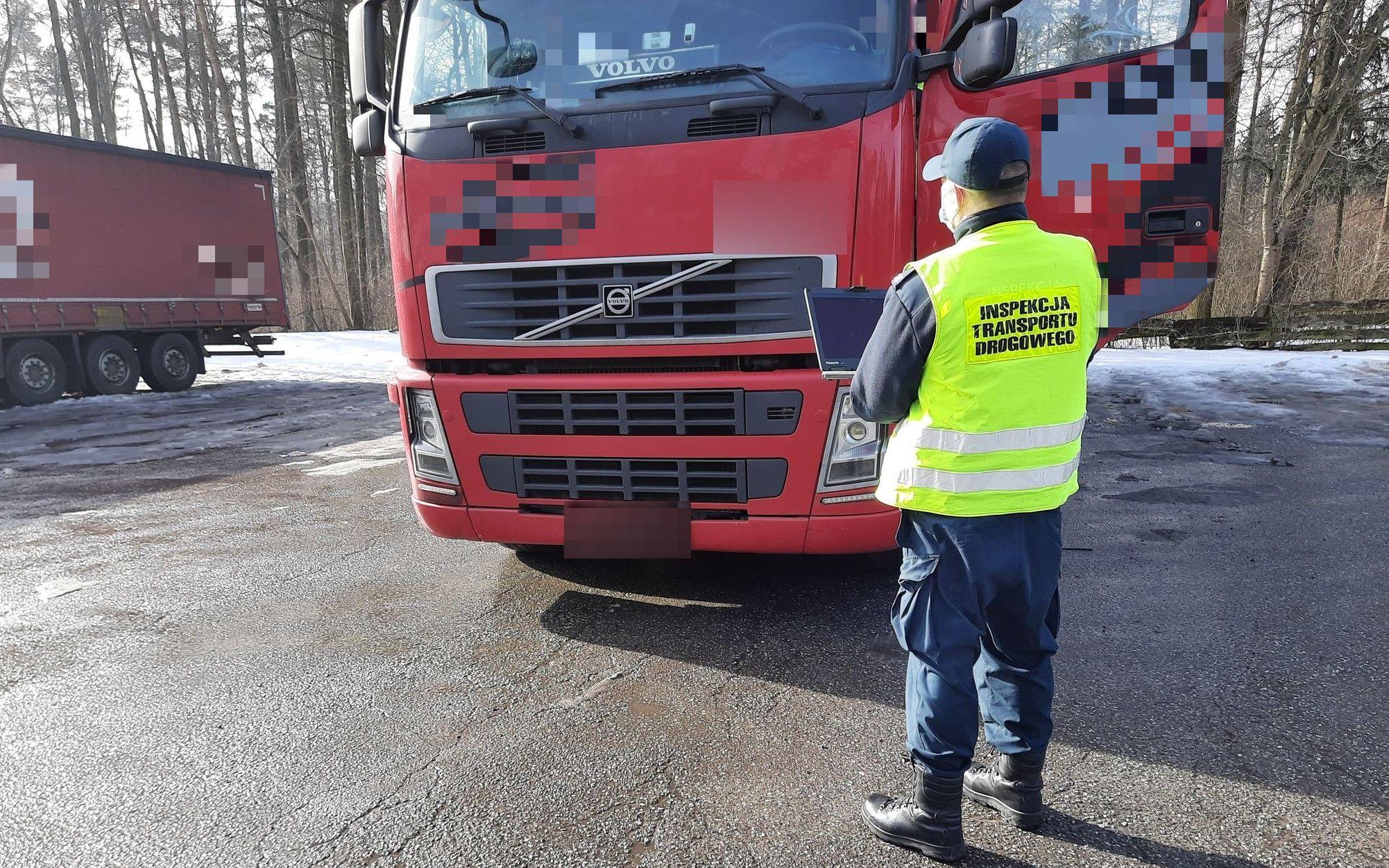 Inspektor kontroluje ciężarówkę z użyciem specjalistycznego sprzętu diagnostycznego. 