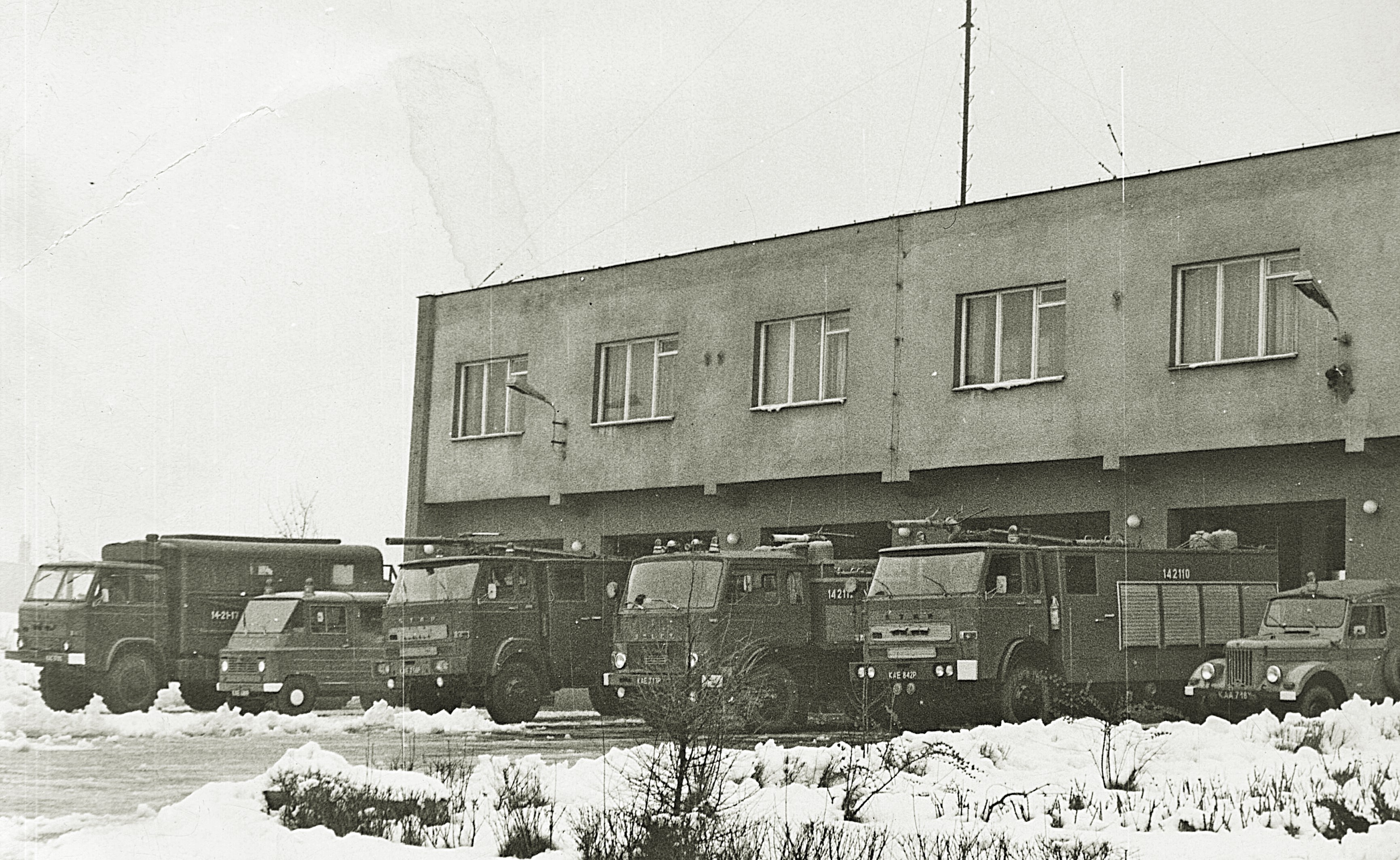 Na historycznym zdjęciu widok Komendy oraz samochodów w aurze zimowej.