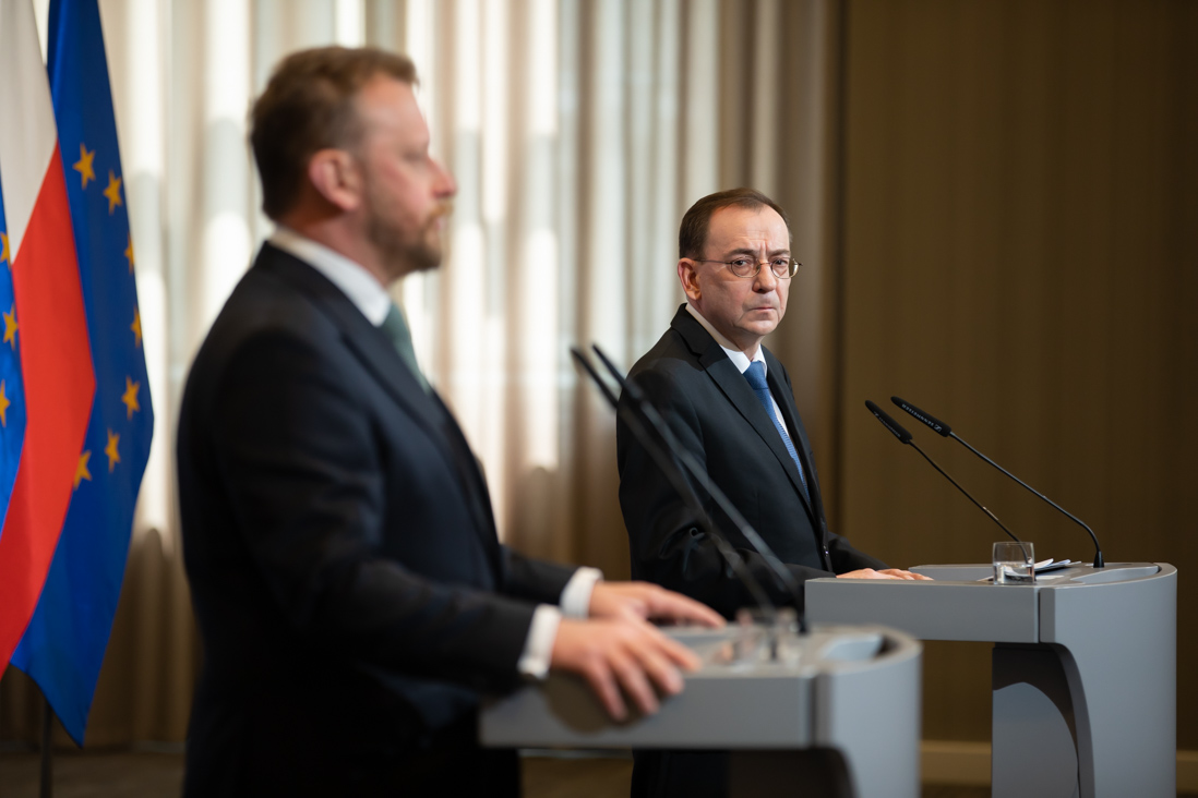 Na zdjęciu minister Mariusz Kamiński patrzy na przemawiającego ministra Łukasza Szumowskiego podczas konferencji prasowej w MSWiA