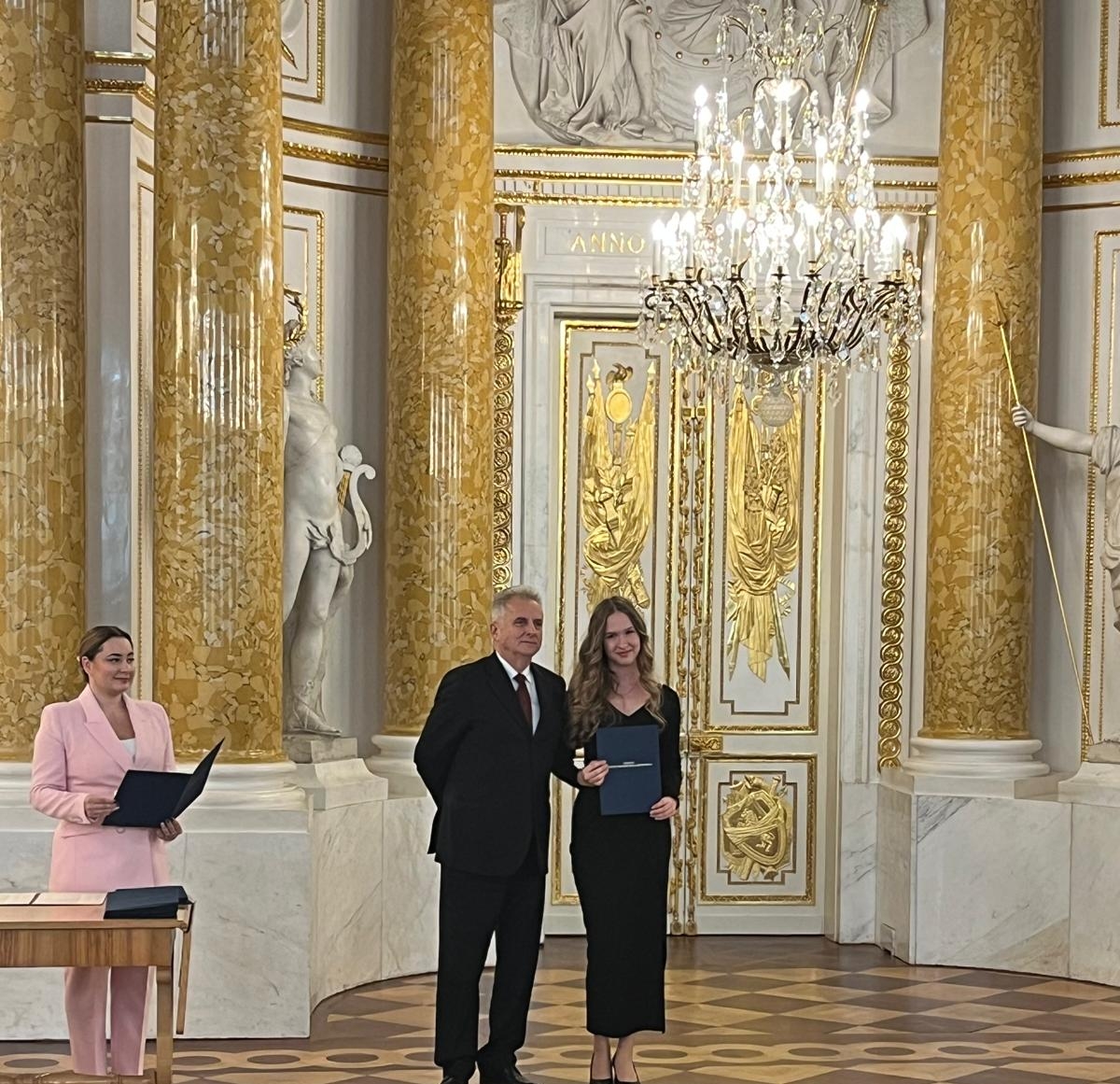 Foto- uczennica Amelia Szmidt odbiera stypendium MKiDN. Zdjęcie z sali Zamku Królewskiego w Warszawie.