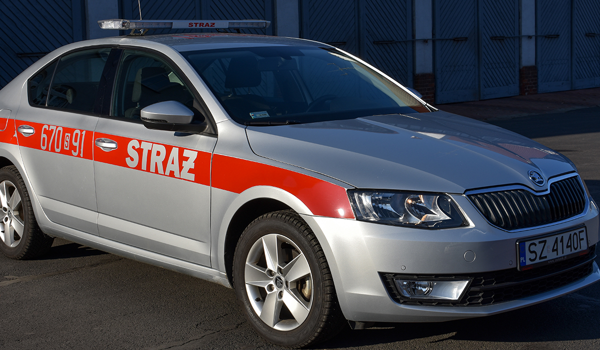 Zdjęcie przedstawia samochód operacyjny - lekki Skoda Octavia na tle budynku Komendy Miejskiej Państwowej Straży Pożarnej w Zabrzu
