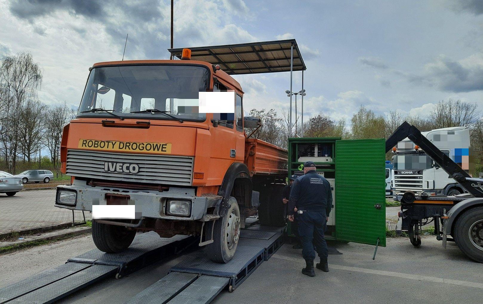 Inspektorzy kontrolują stan techniczny ciężarówki na mobilnej stacji diagnostycznej ITD.