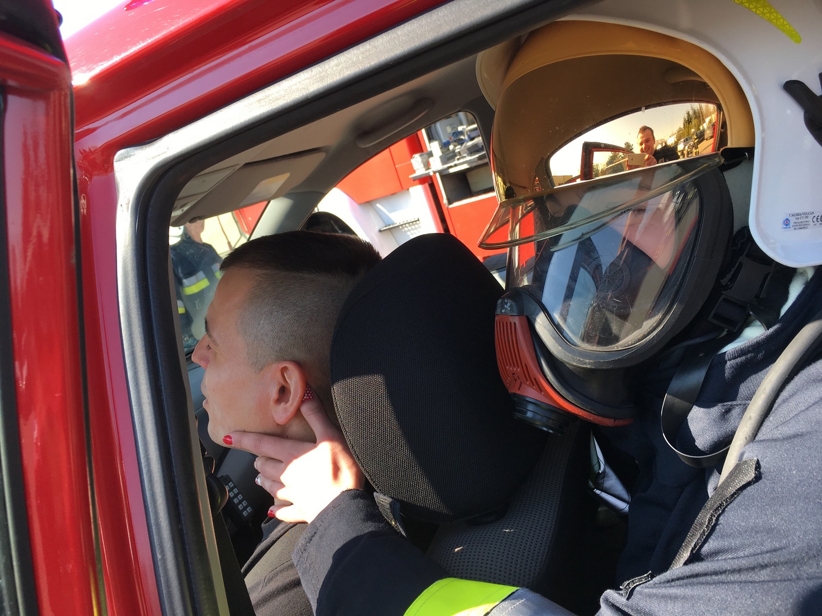 Zdjęcie przedstawia strażaka OSP i pozoranta w samochodzie podczas udzielania pomocy.