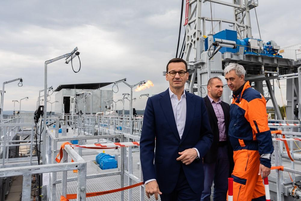 Premier Mateusz Morawiecki idzie po placu wiertniczym.