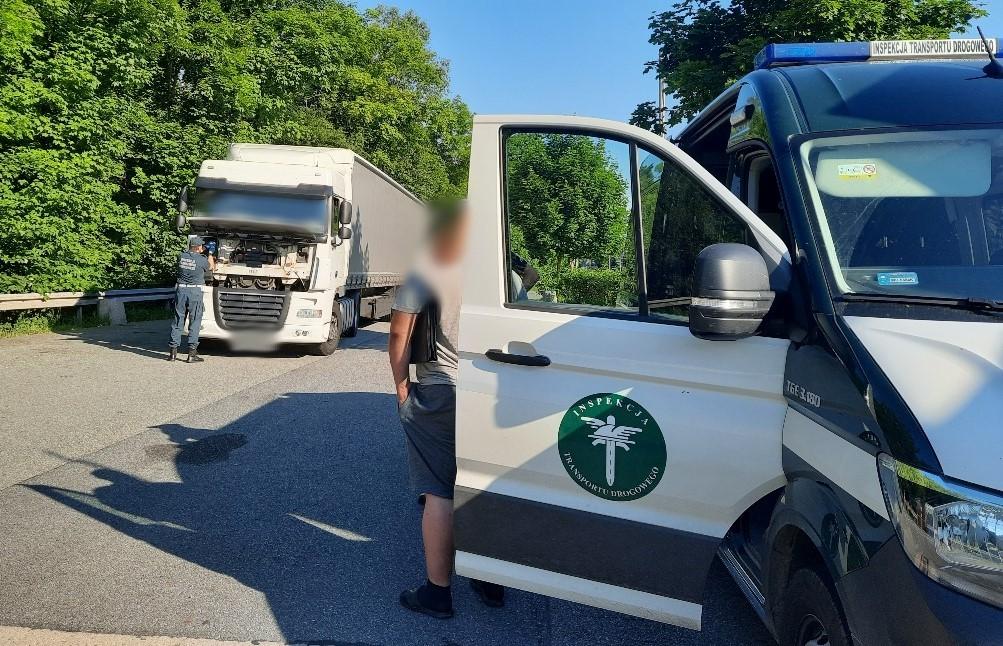 Część radiowozu ITD i stojąca za nim ciężarówka.