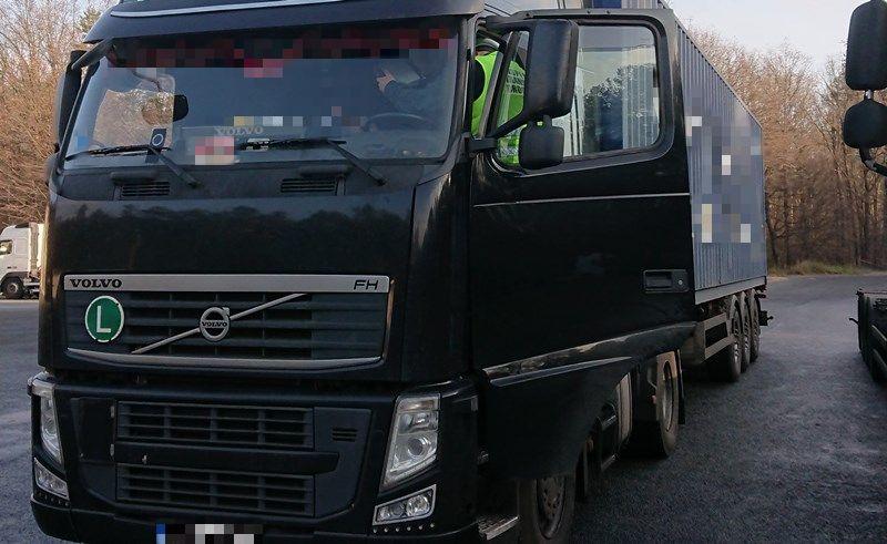 Inspektor kontroluje tachograf w ciężarówce.