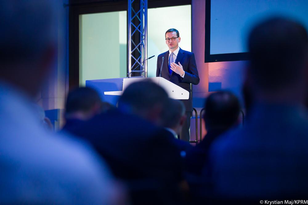 Premier Mateusz Morawiecki przemawia przed ludźmi.