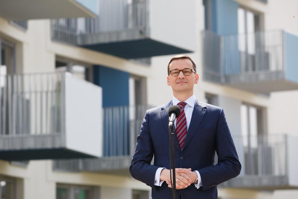 Premier Mateusz Morawiecki, a w tle mieszkania w Białej Podlaskiej.