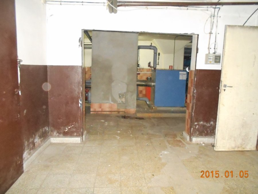 Zdjęcie przedstawia pomieszczenie kotłowni przed remontem w budynku „C” KP PSP Myślenice. Na dalszym planie widać zamontowany piec olejowy