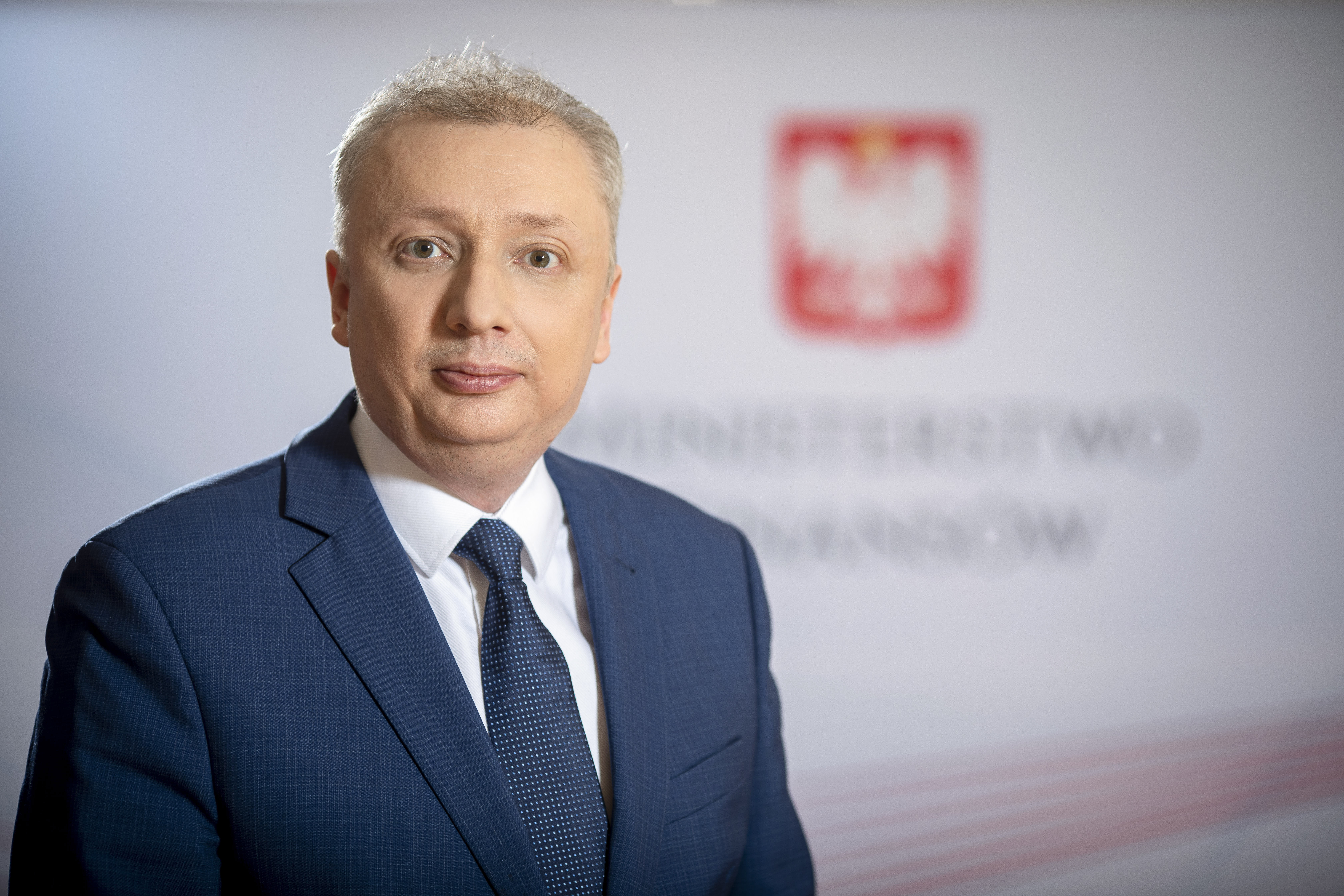 Sebastian Skuza Sekretarz Stanu, Generalny Inspektor Informacji Finansowej na tle baneru MF