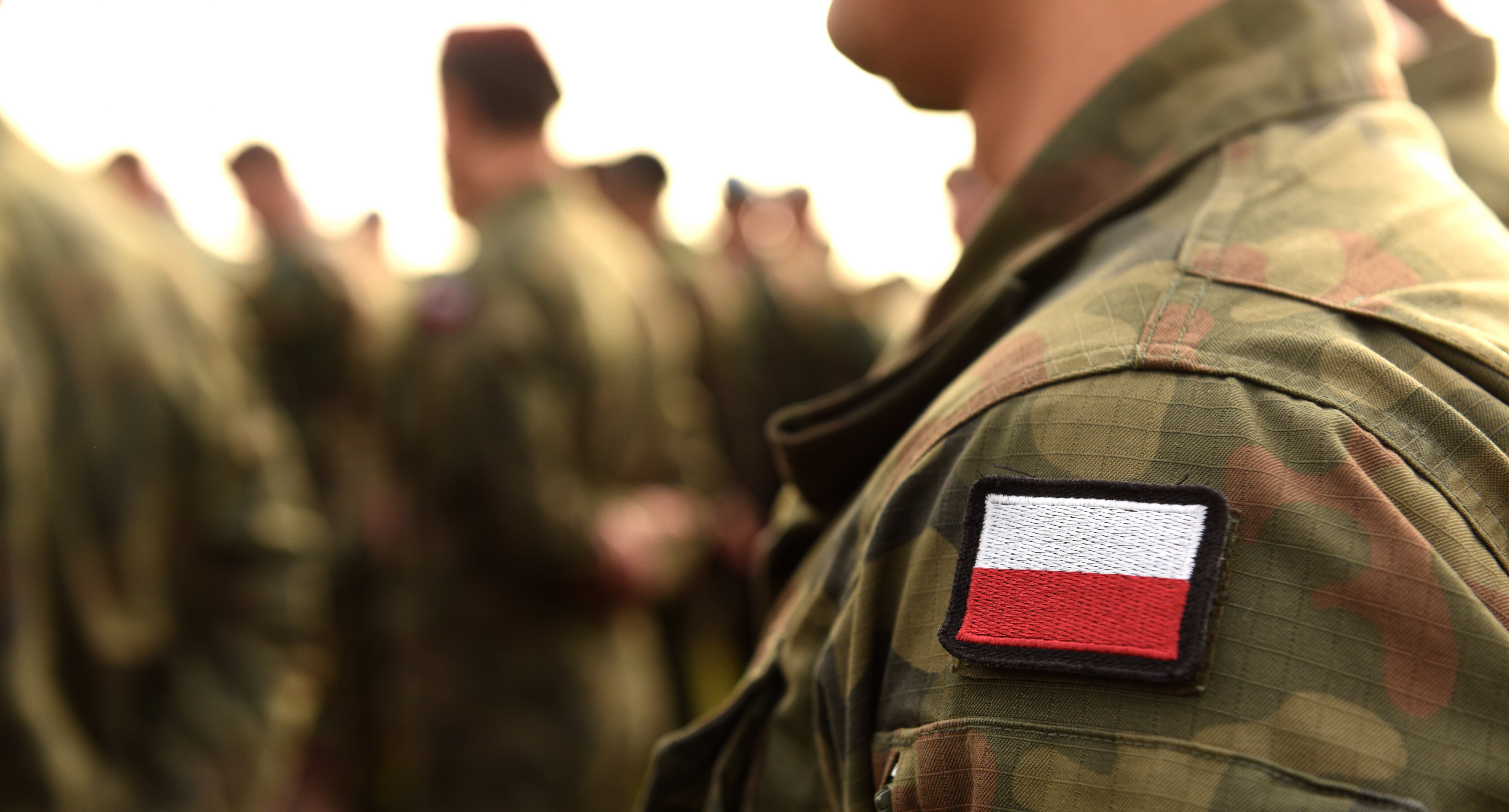 Lewe ramie żołnierza w mundurze z flagą biało czerwoną 